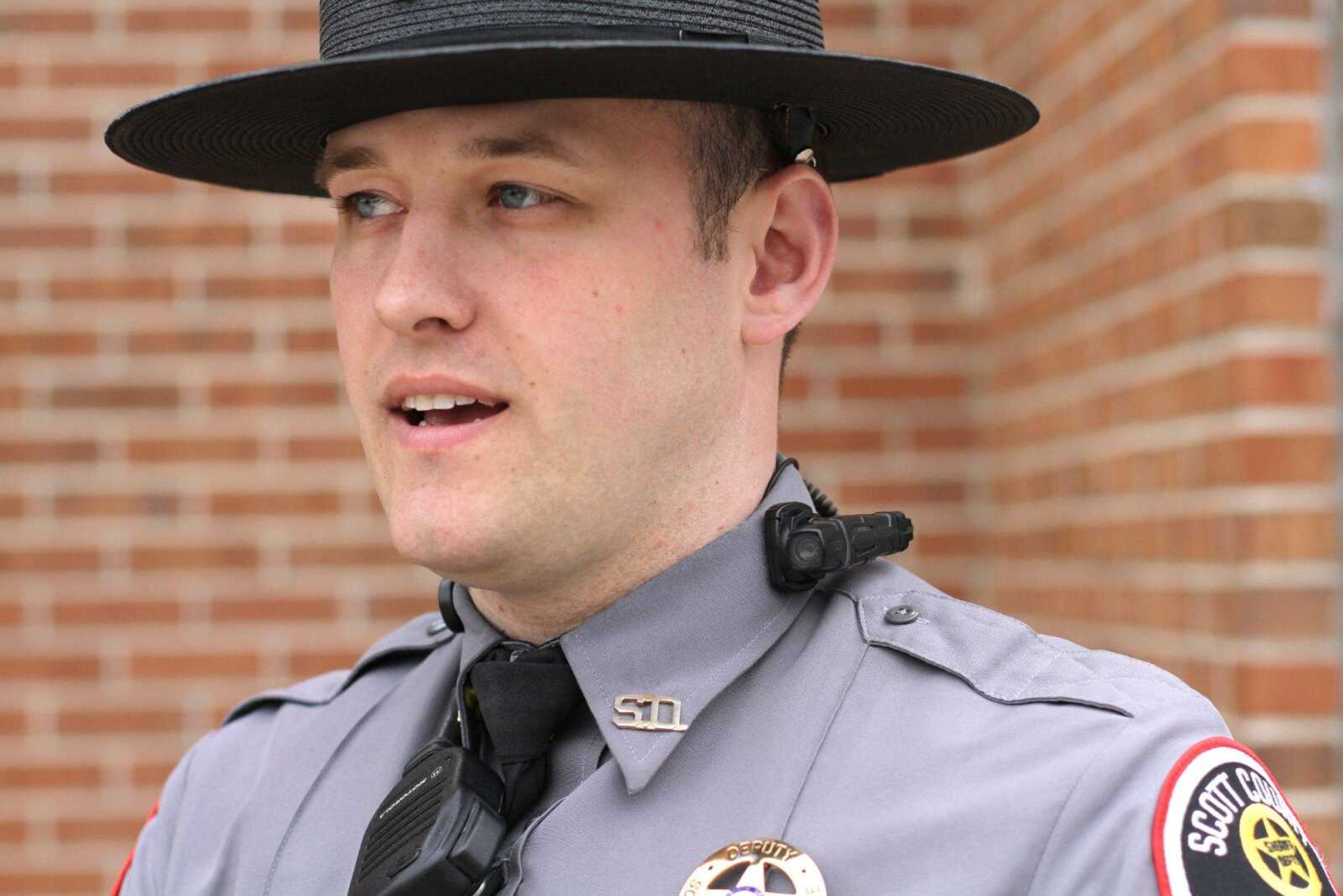 Scott County Sheriff's senior deputy Matt Scroggins demonstrates the Taser AXON Flex body camera unit Friday that's affixed to the side his collar. (Glenn Landberg)