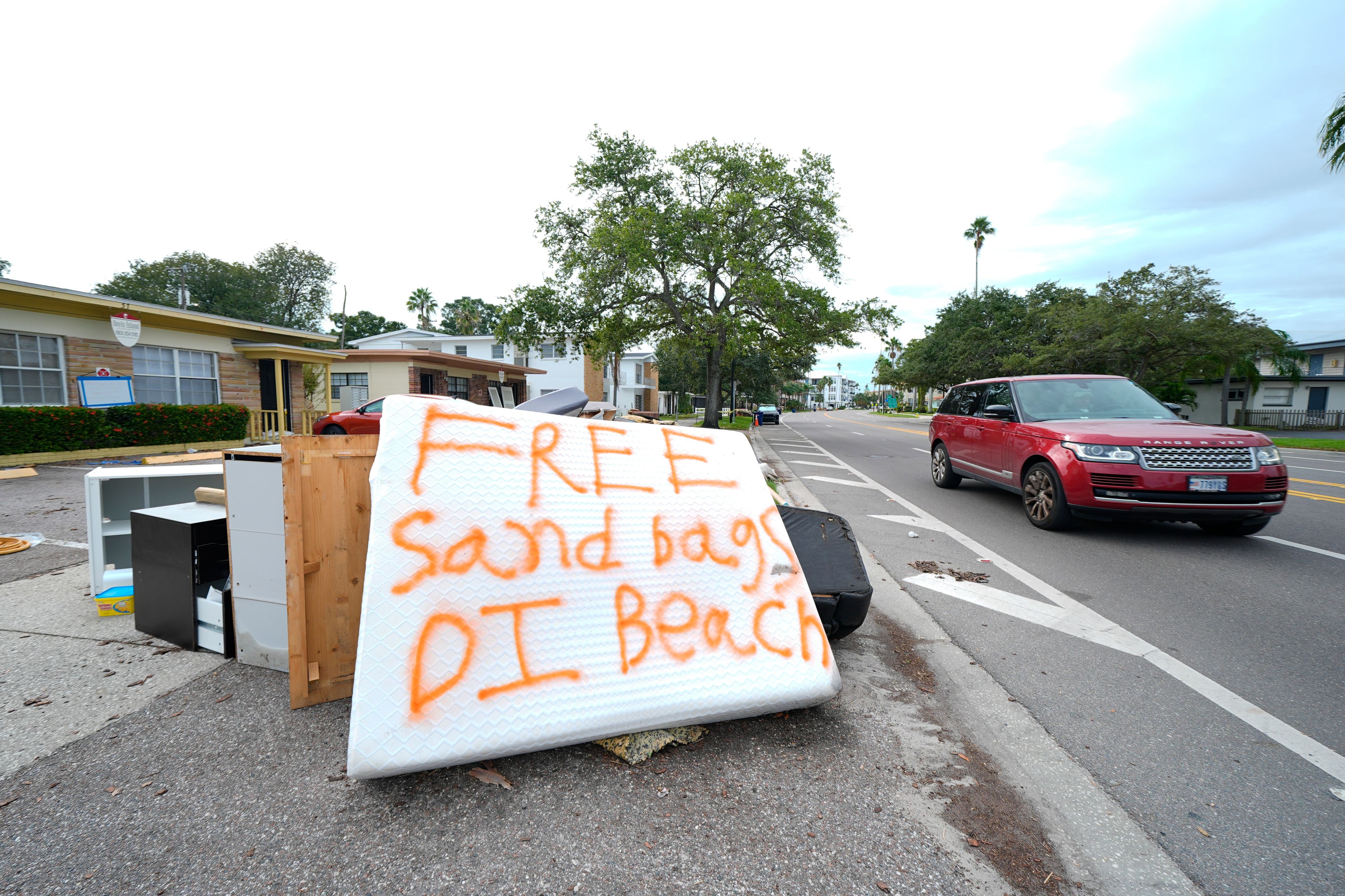 A message is seen on a mattress on a pile of furniture destroyed during Hurricane Helene as residents in the Davis Islands community of Tampa, Fla., prepare for the arrival of Hurricane Milton, Tuesday, Oct. 8, 2024. (AP Photo/Julio Cortez)