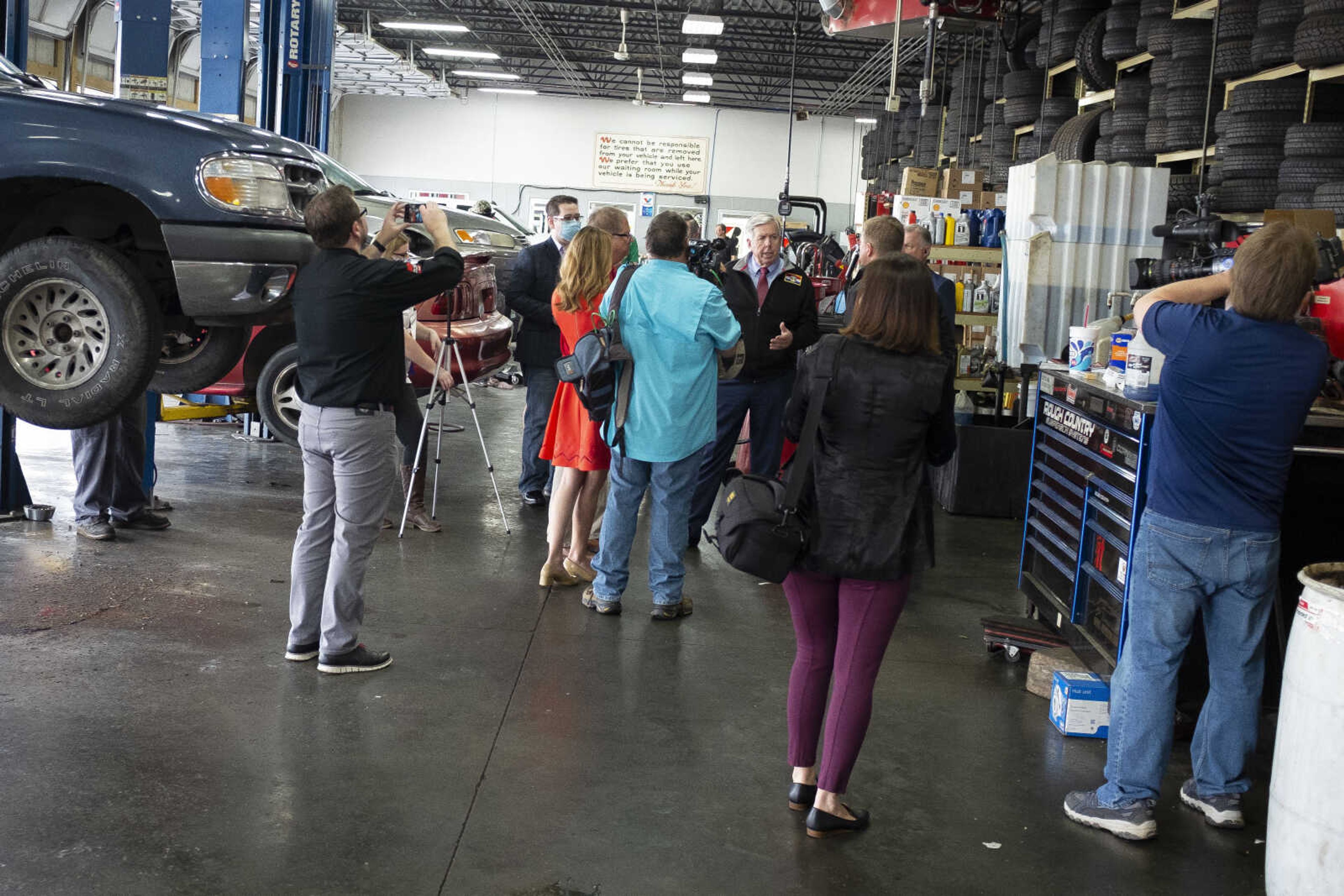 Missouri Gov. Mike Parson, center of group and facing cameras, speaks while making a visit Thursday, May 14, 2020, at Plaza Tire Service in Cape Girardeau.