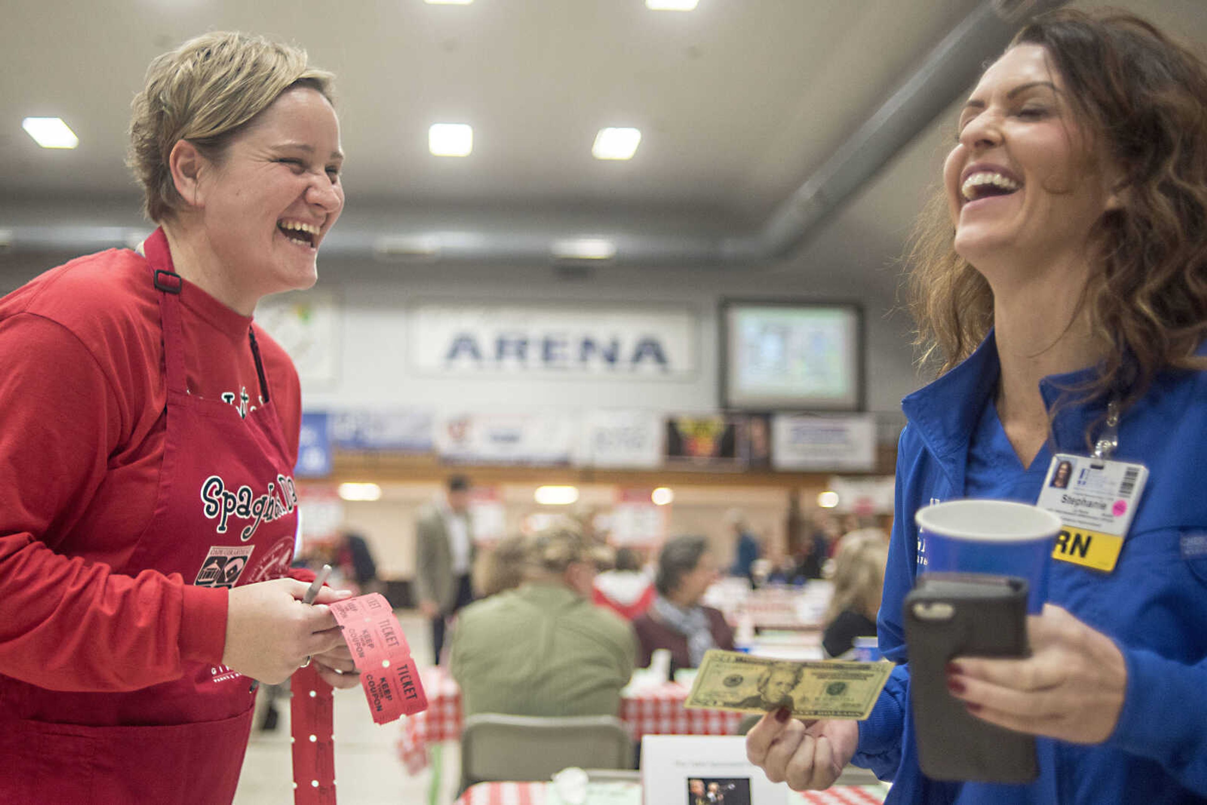 Cindy Henry, left, lauhgs while selling Stephanie LaPierre a string of raffle tickets during the Parks & Recreation Foundation's Spaghetti Day Thursday, Nov. 7, 2019, at the A.C. Brase Arena building in Cape Girardeau.