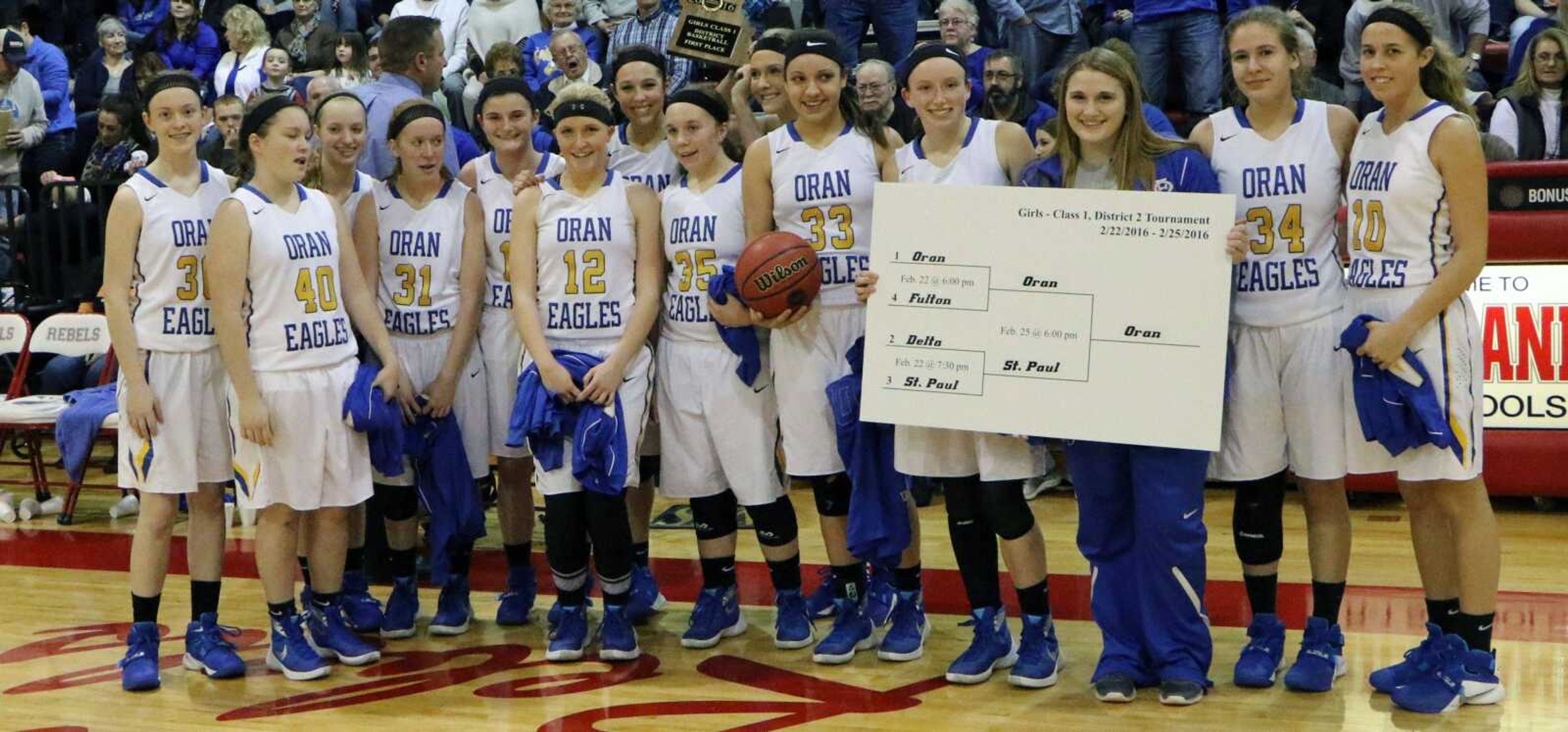 Oran players hold up the Class 1 District 2 tournament bracket after defeating St. Paul Lutheran 73-20 in the championship game Thursday at Richland High School in Essex, Missouri.