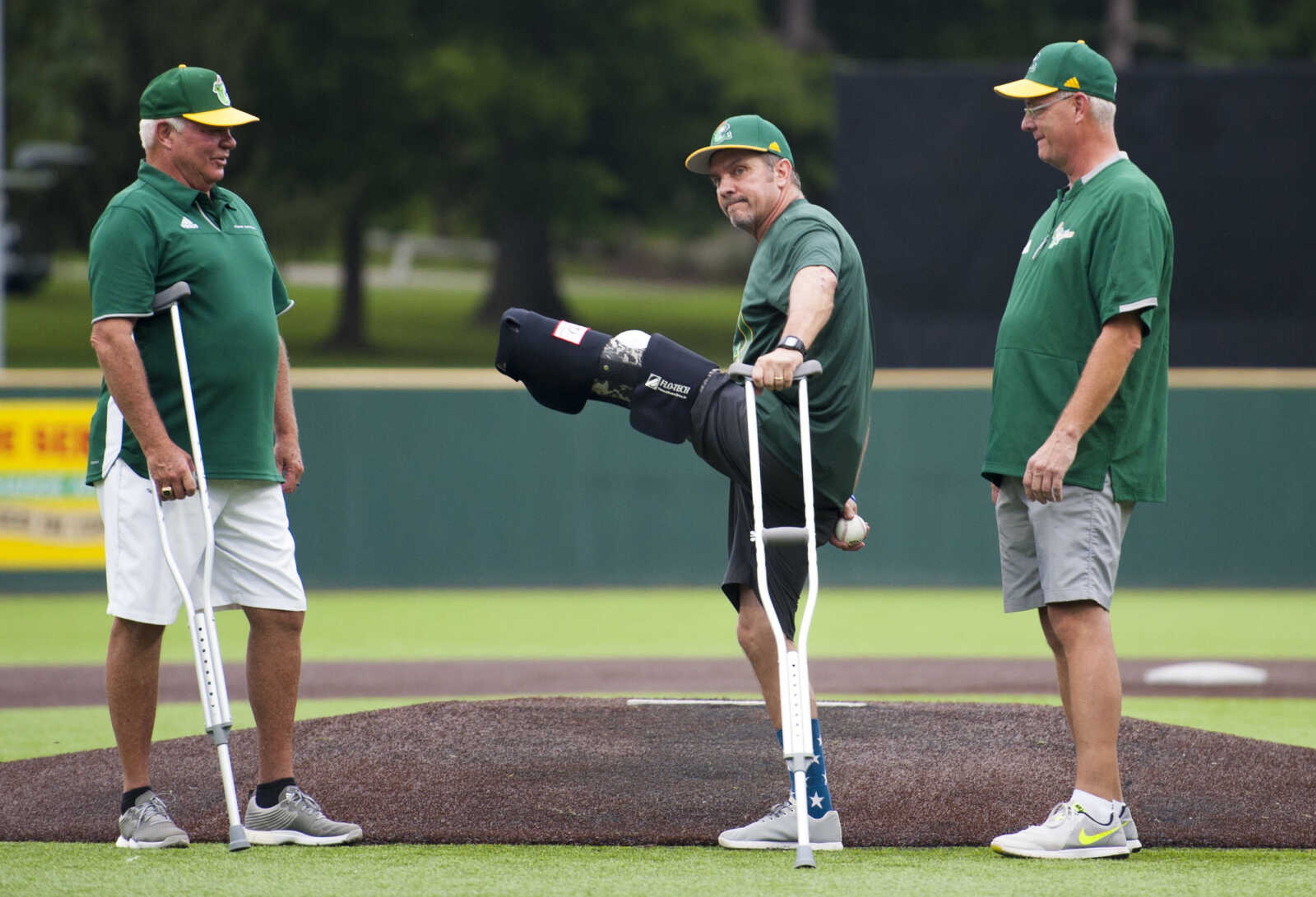 Cape Catfish general manager Mark Hogan, left, and Ross Gartman, right, watch retired Navy captain David Cantrell, center, throw out the opening pitch to begin the Prospect League West Divisional playoff game against the DuPage Pistol Shrimp on Thursday, Aug. 8, 2019, at Capaha Field in Cape Girardeau.