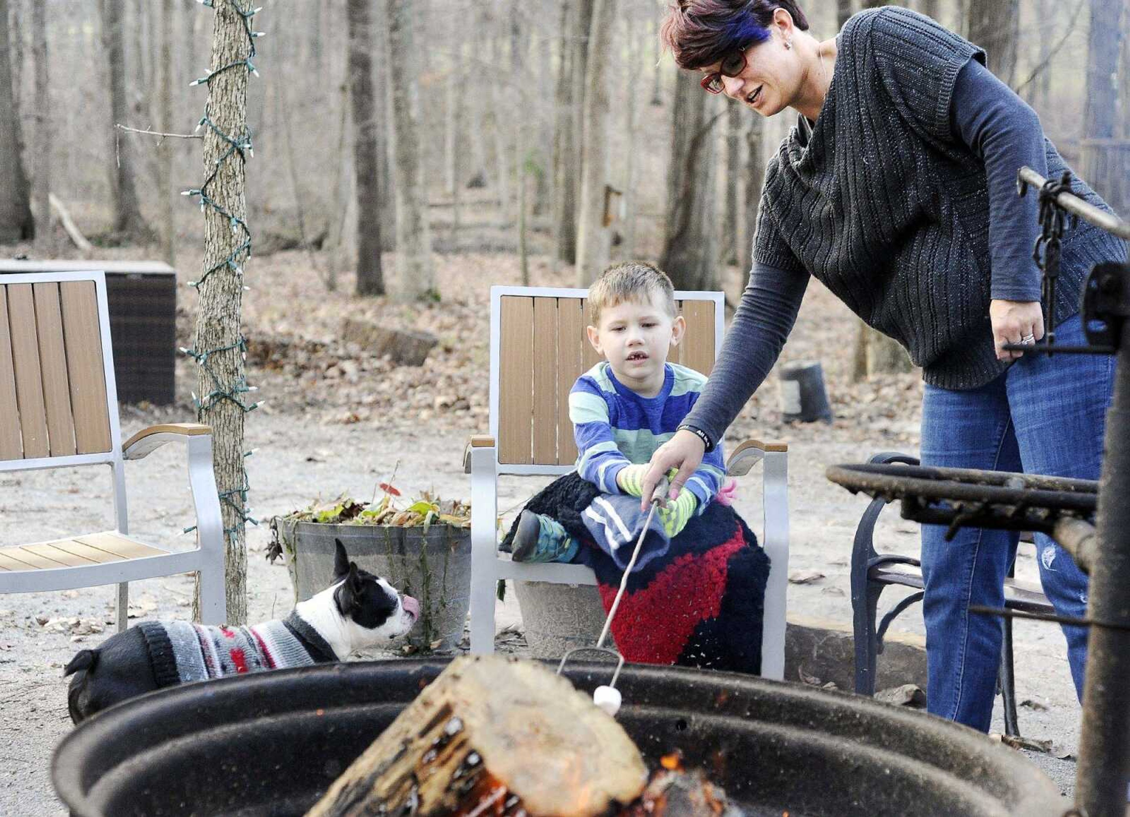 Vanessa Stevens helps her son, Declan, roast a marshmallow for a s'more Tuesday as the family dog, Millie, waits for a graham cracker. (Laura Simon)