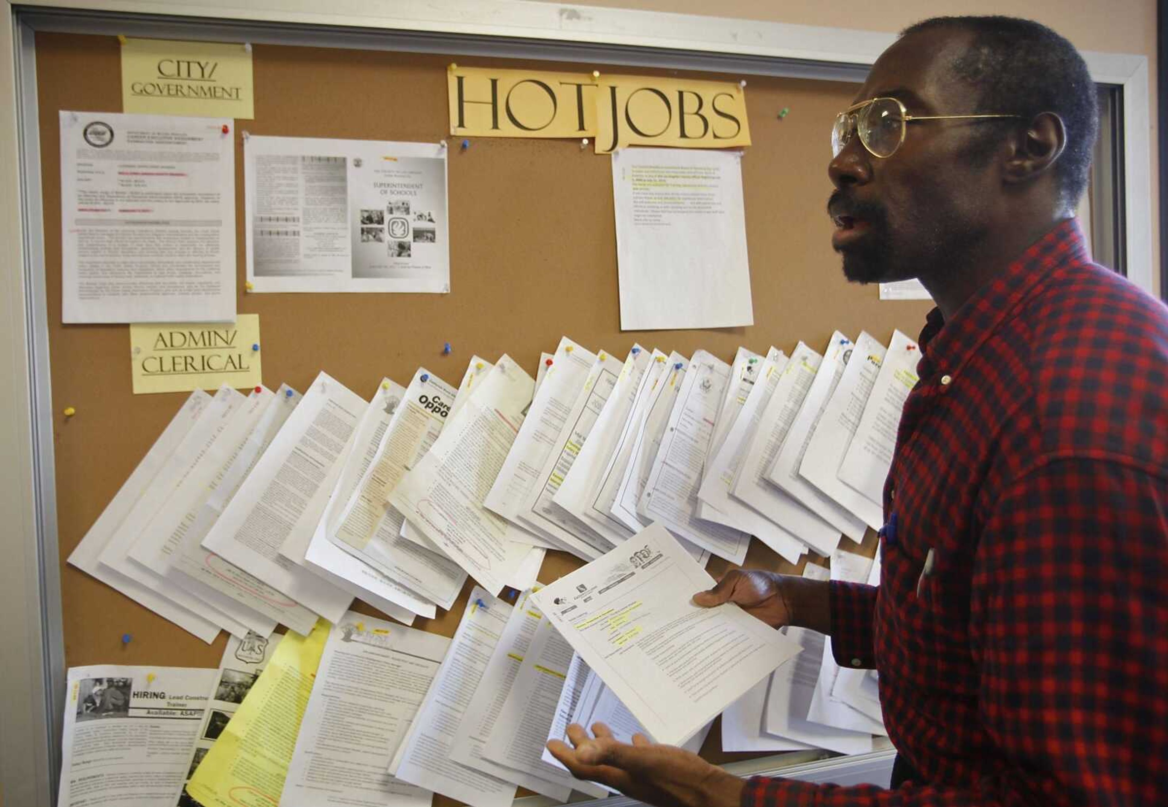 Job seeker Richard Phillips looks for a video post-production job opportunity Thursday at the Verdugo Job Center in Glendale, Calif. Finding a job remains a struggle 20 months after the recession technically ended. (Damian Dovarganes ~ Associated Press)