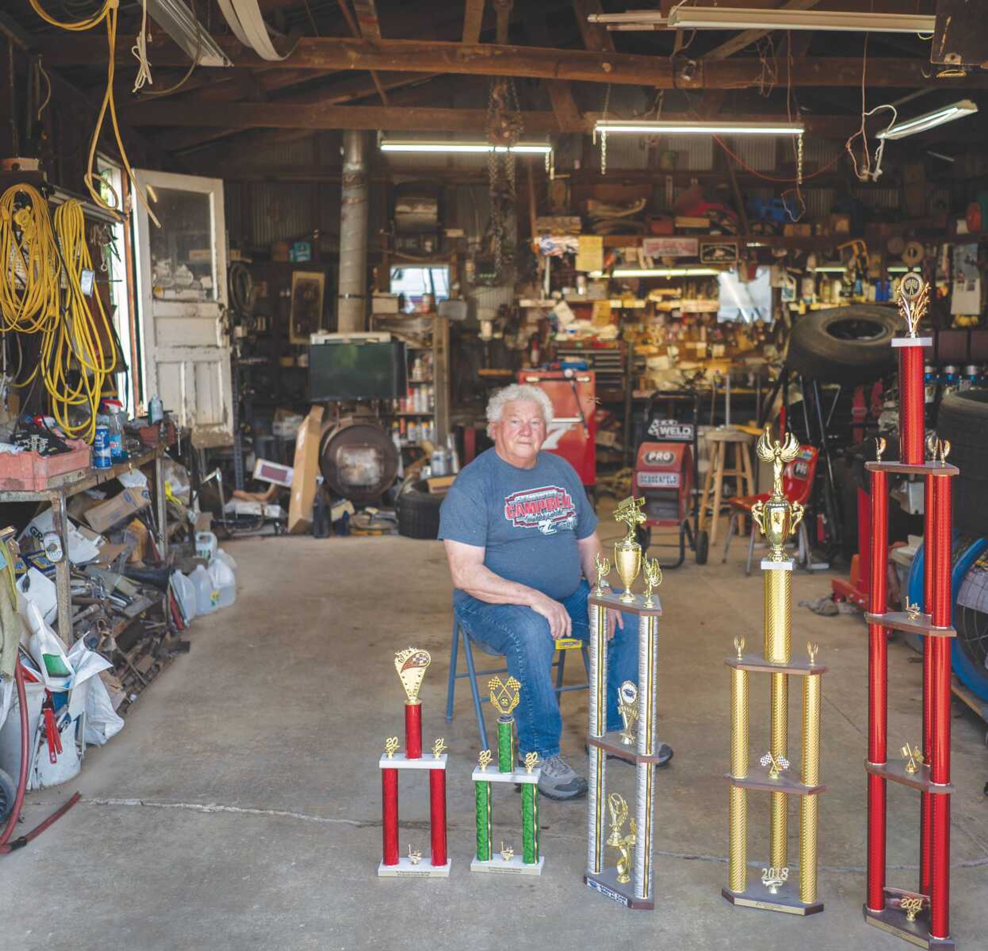 Quentin Campbell sits in his garage in Perryville, Mo., with some of the trophies he's won for the sprint cars he builds. Campbell began building and racing sprint cars when he was 21 years old.