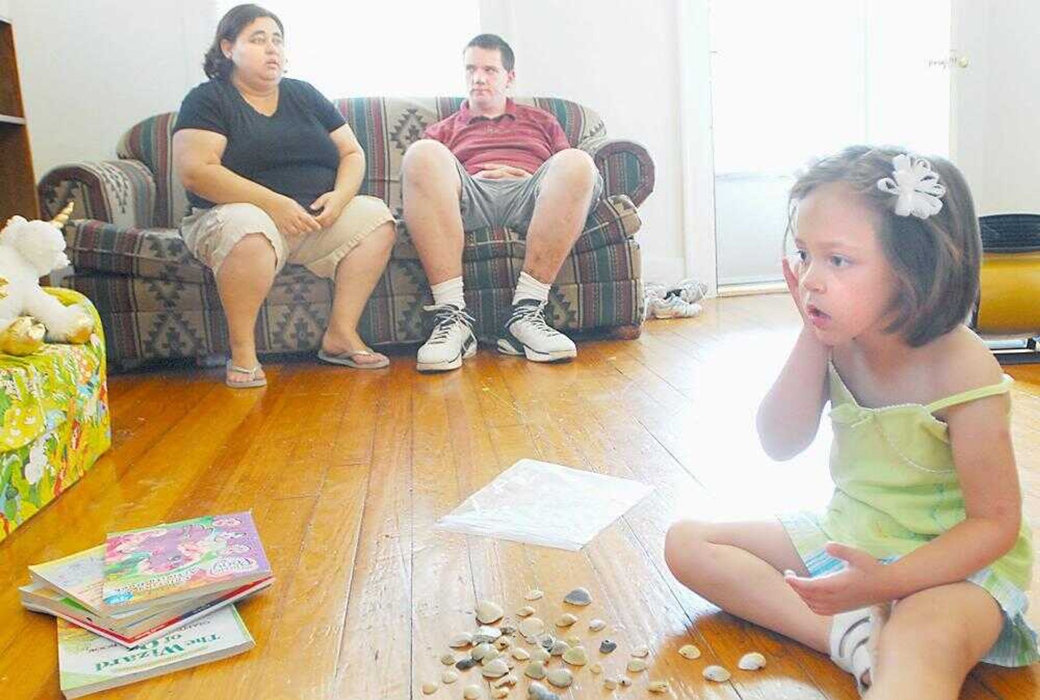 Zoe Dunning put a seashell up to her ear while playing with her shell collection while her mother, Kimberly Dunning, and her mother's boyfriend, Lowell Milner, talked about their struggles with their disorders in the living room of their Cape Girardeau home. (Diane L. Wilson)