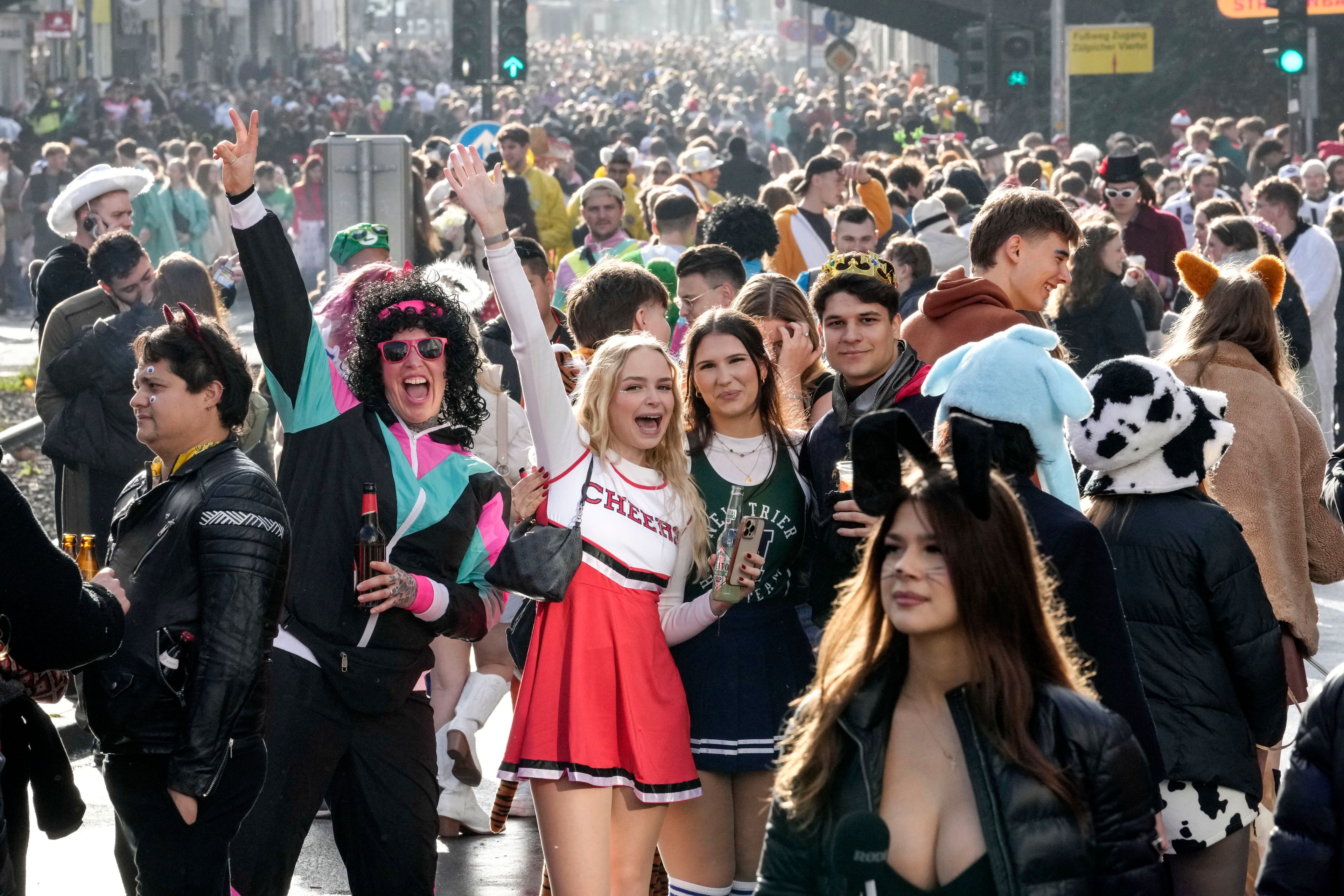 Revelers celebrate at the overcrowded Zuelpicher neighborhood while tens of thousands of carnival fools take to the streets of Cologne, Germany, on Monday, Nov. 11, 2024, heralding the official start of the carnival season. (AP Photo/Martin Meissner)