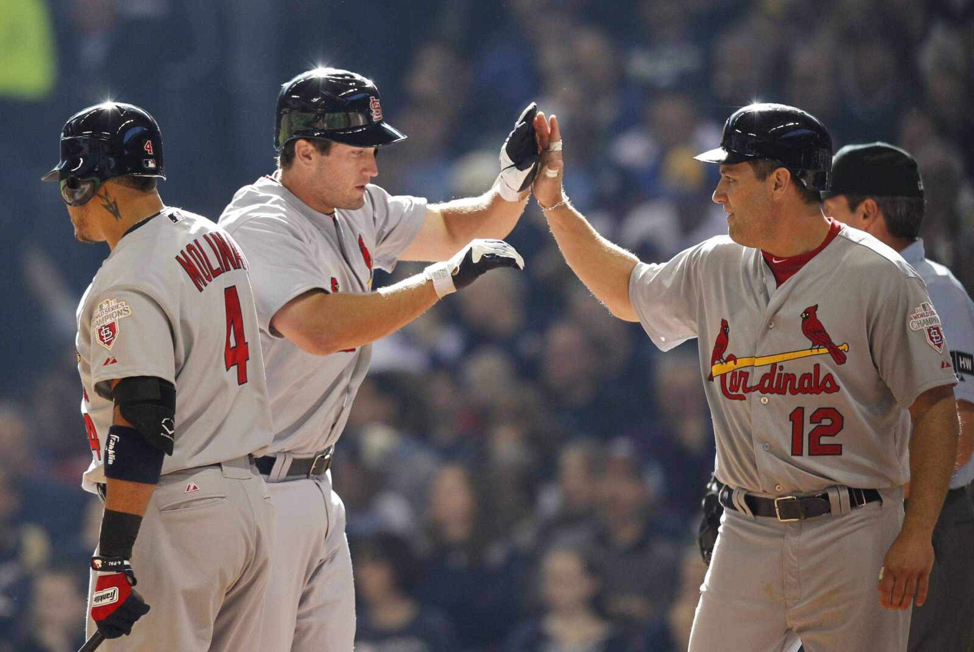 Cardinals third baseman David Freese, center, receives a high-five from teammate Lance Berkman, right, after Freese hit a two-run home run during the third inning Friday in Milwaukee. (JEFFREY PHELPS ~ Associated Press)