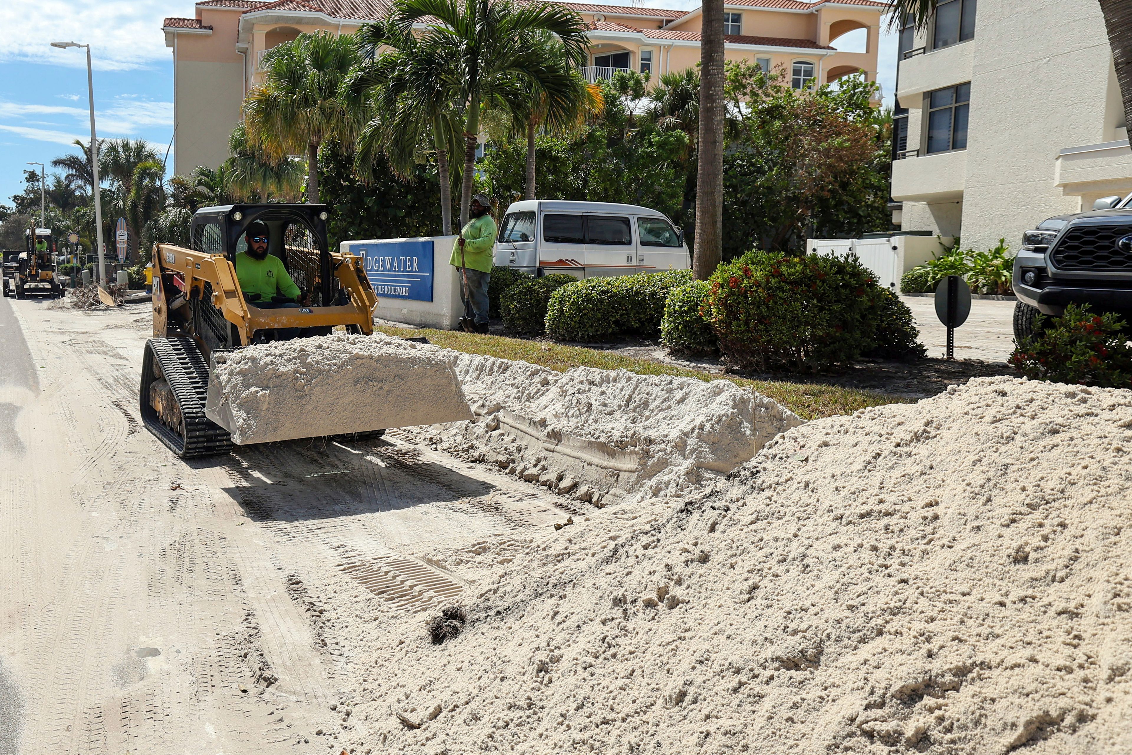 Crews continue to clean up sand caused by the flooding in Hurricane Helene on Gulf Boulevard on Wednesday, Oct. 2, 2024, in Indian Rocks Beach, Fla. (AP Photo/Mike Carlson)