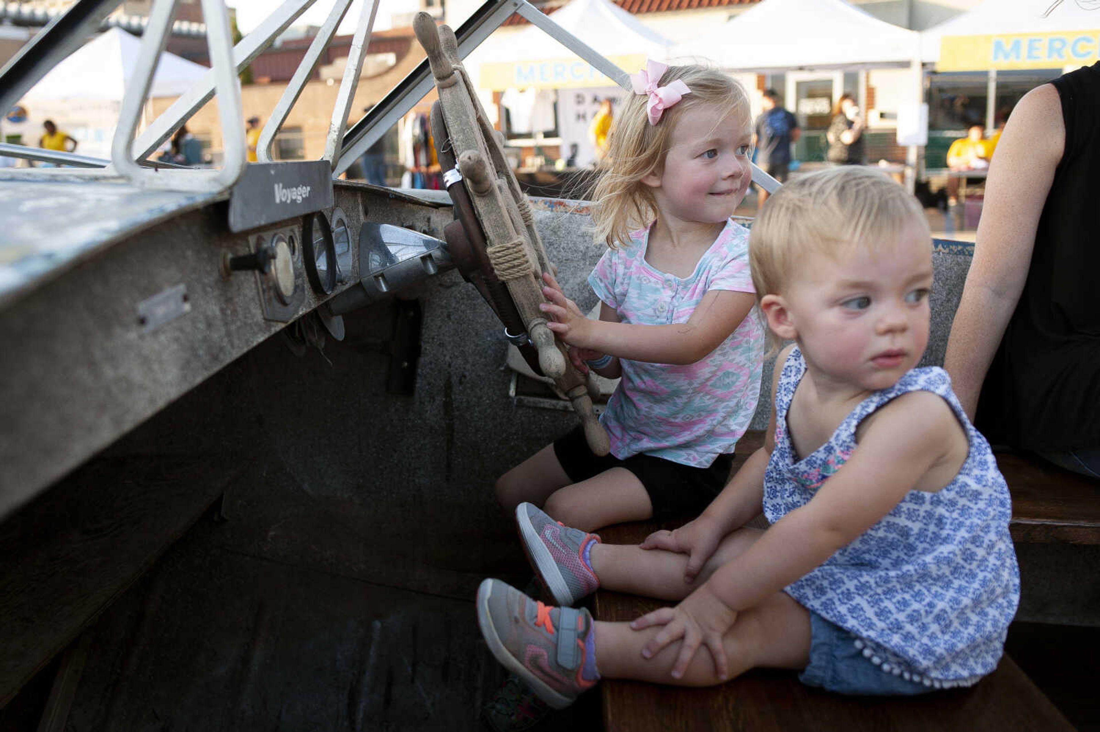 Avery Heuring, 3, and Morgan Heuring, 1, of Cape Girardeau, look in the direction of the main stage while sitting in a boat during Shipyard Music and Culture Festival on Friday, Sept. 27, 2019, in Cape Girardeau.