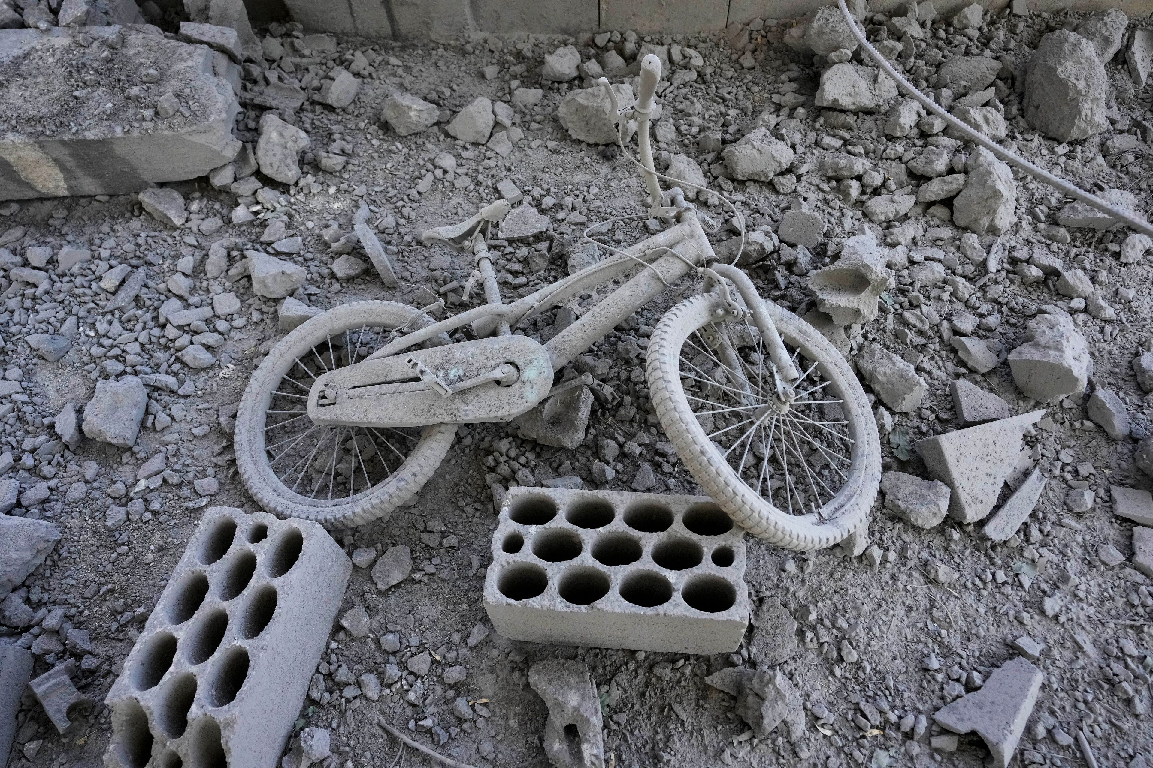 A damaged bicycle on the ground inside a building that was hit by an Israeli airstrike in Baalbek, east Lebanon, Monday, Oct. 7, 2024. (AP Photo/Hassan Ammar)