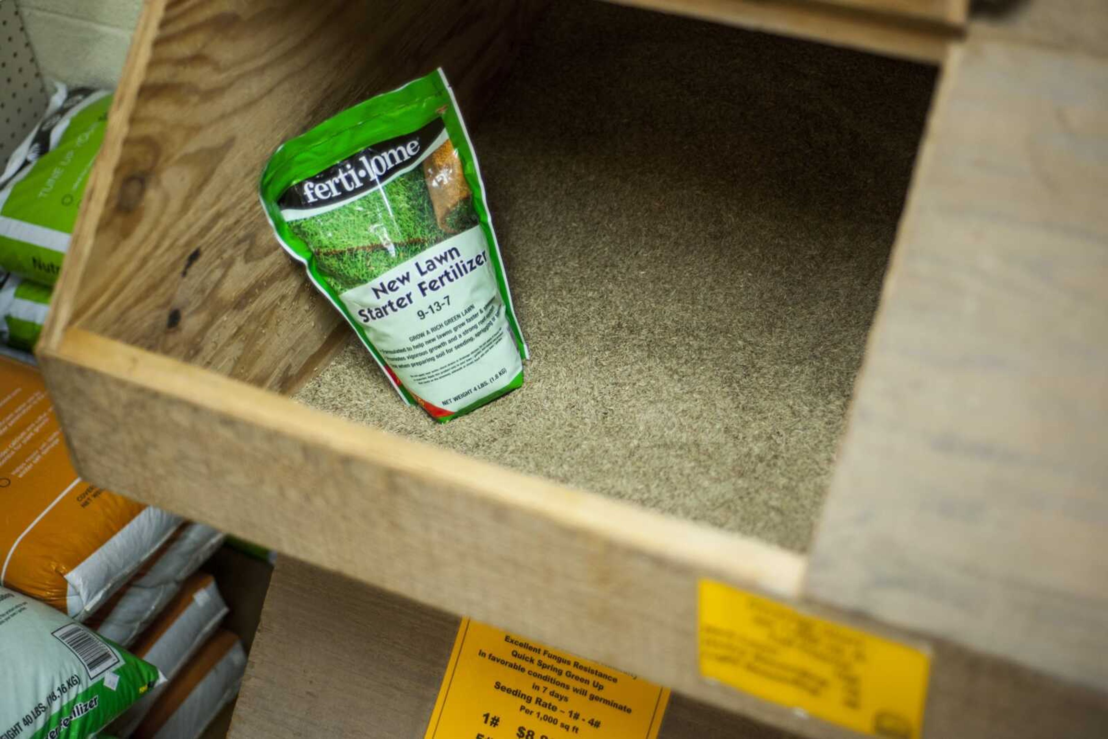 Lawn fertilizer is seen in a shelf of grass seed Tuesday at Sunny Hill Nursery in Cape Girardeau.