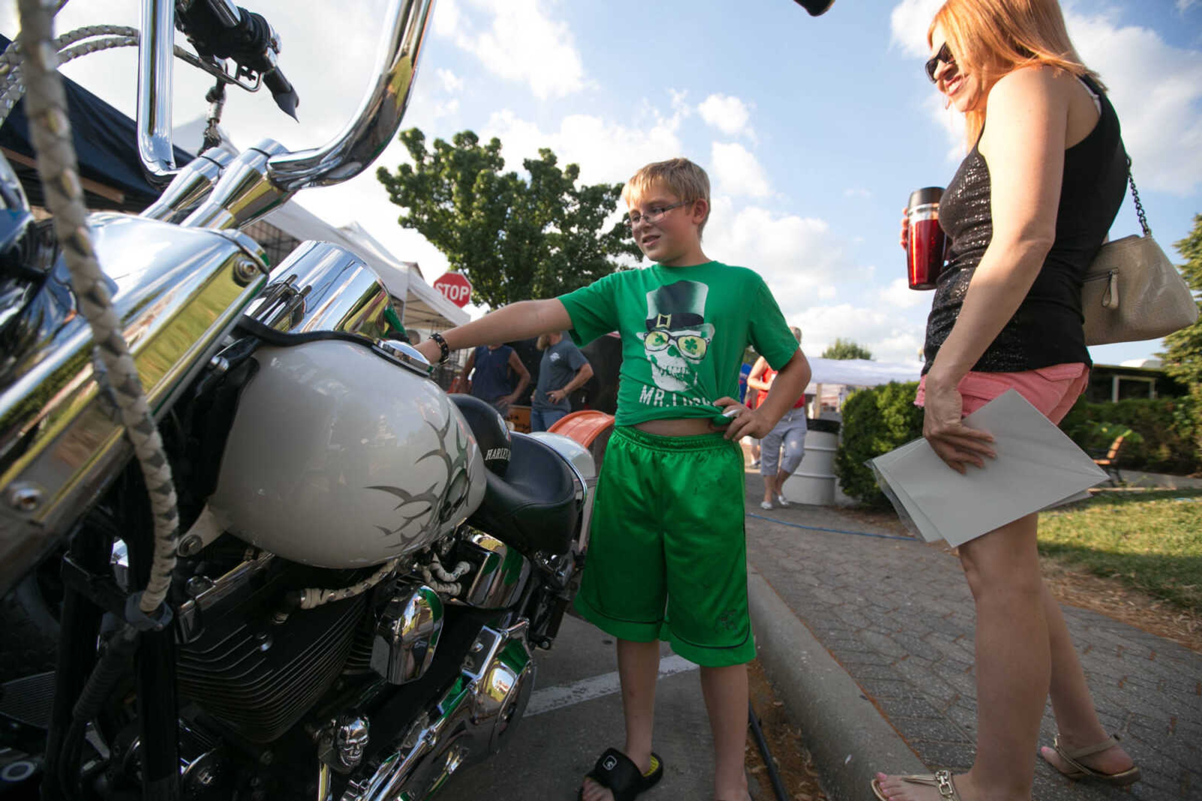 GLENN LANDBERG ~ glandberg@semissourian.com

Hunter Groves shows a motorcycle to his mother Loren Miller during the 4th Annual Bikers on the Square Friday, June 17, 2016 in Perryville, Missouri.