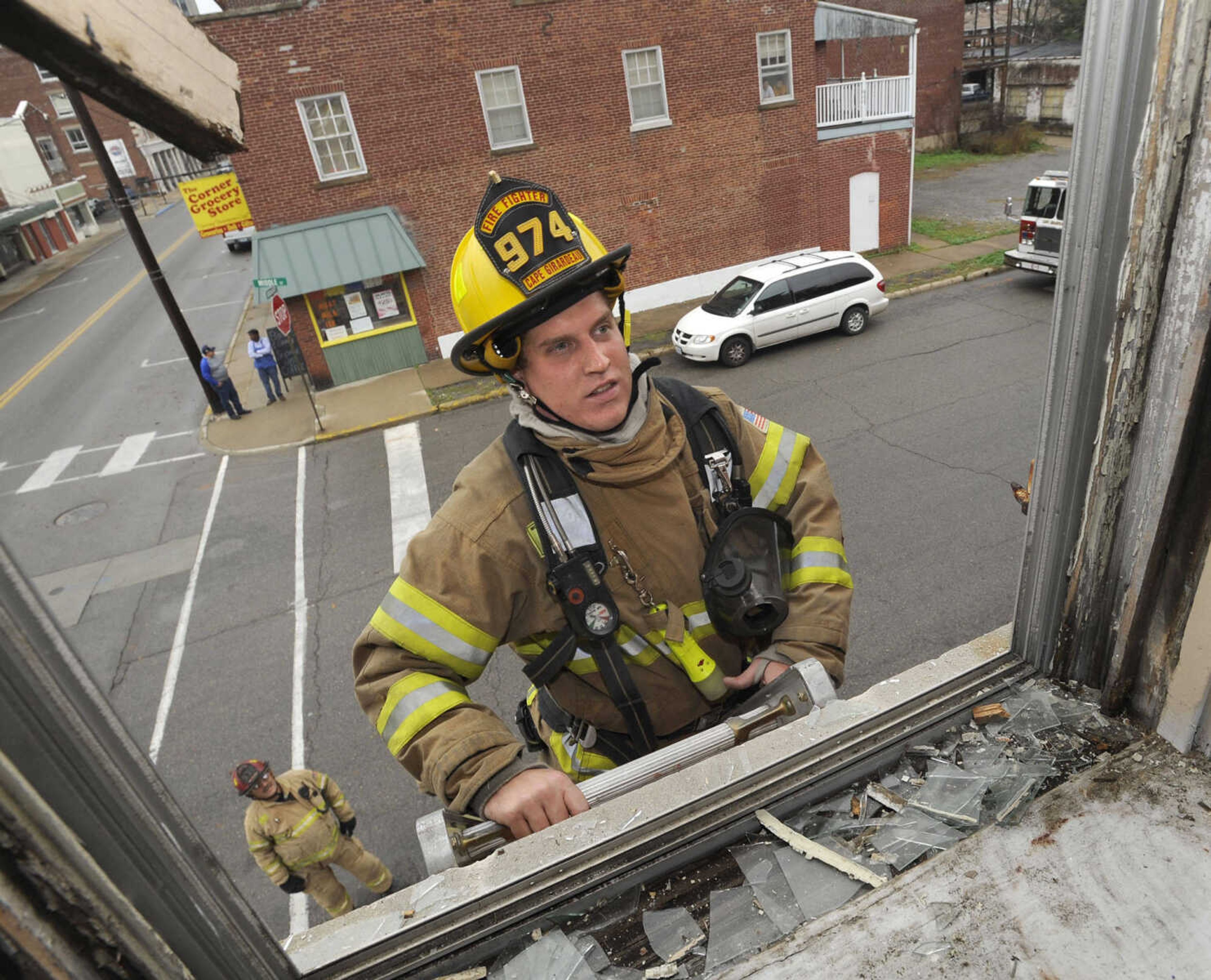 Firefighter Bryan Stroer climbs the ladder that was used to break the second-floor window.