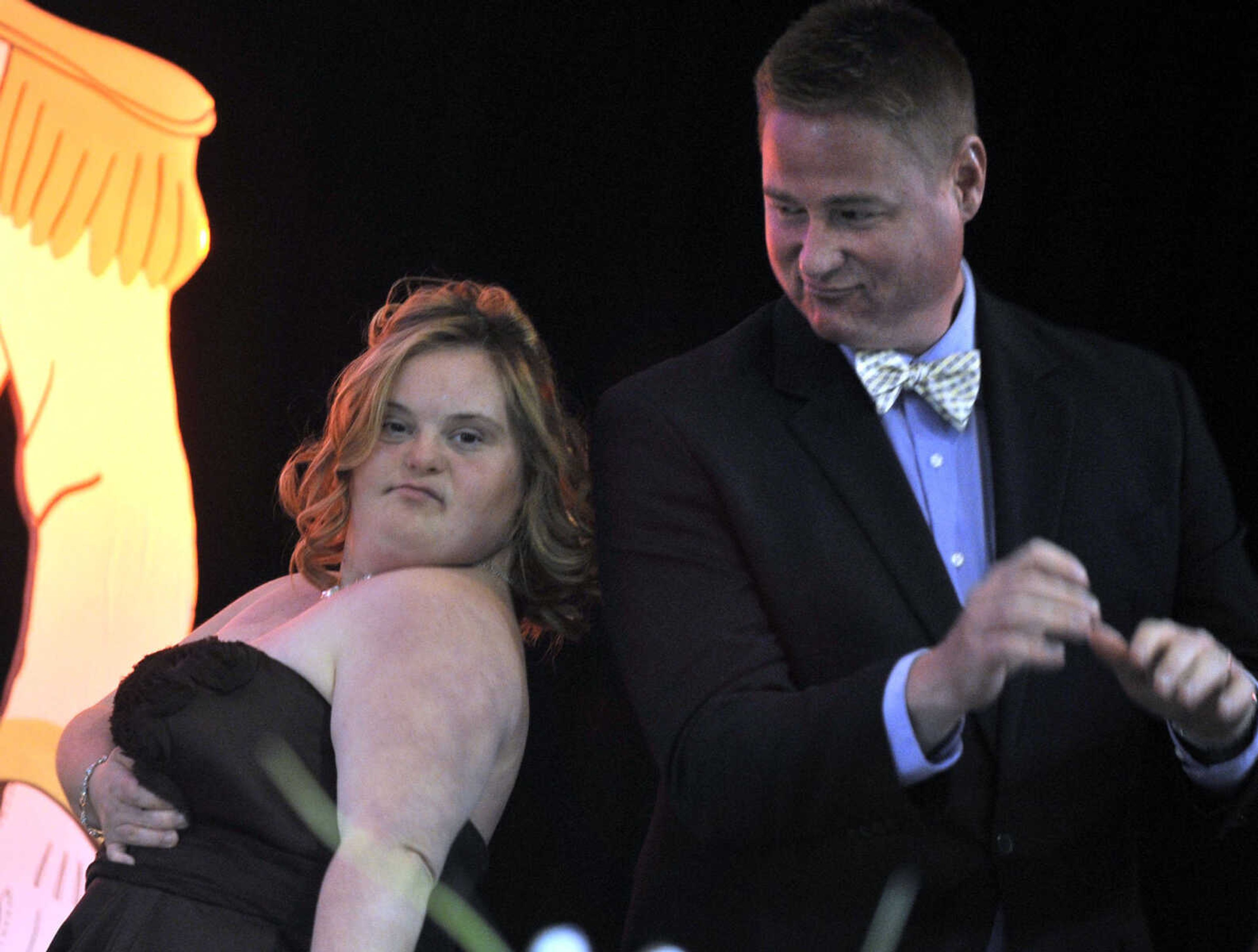 Ashley Brotherton works the stage with announcer Jeff Cunningham in the age 20-25 division of the S. E. Missouri Angels Pageant on Saturday, April 26, 2014 at Scott City High School.