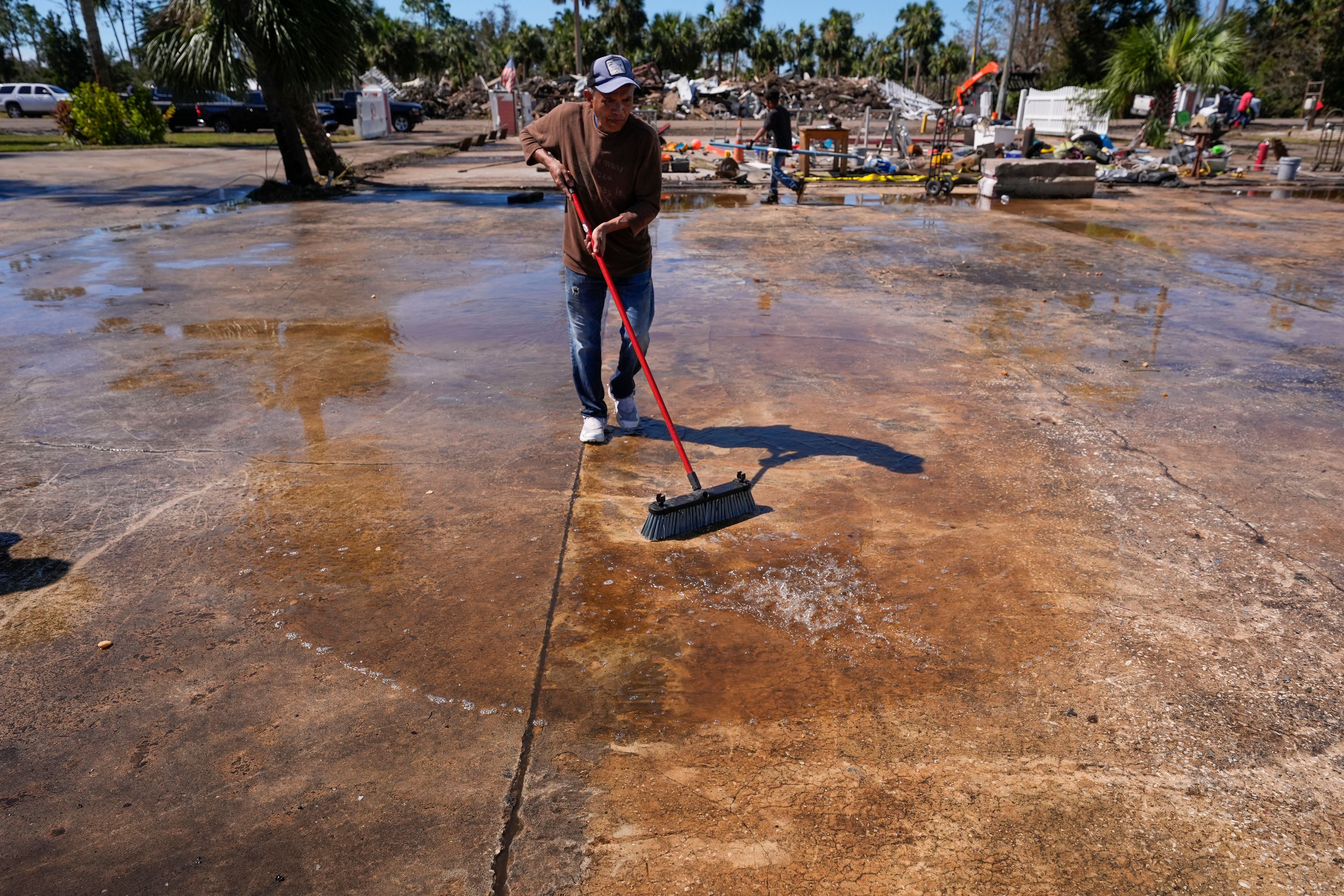 Workers clean up a dock where a boat shed was destroyed in the aftermath of Hurricane Helene, in Jena, Fla., Sunday, Sept. 29, 2024. (AP Photo/Gerald Herbert)