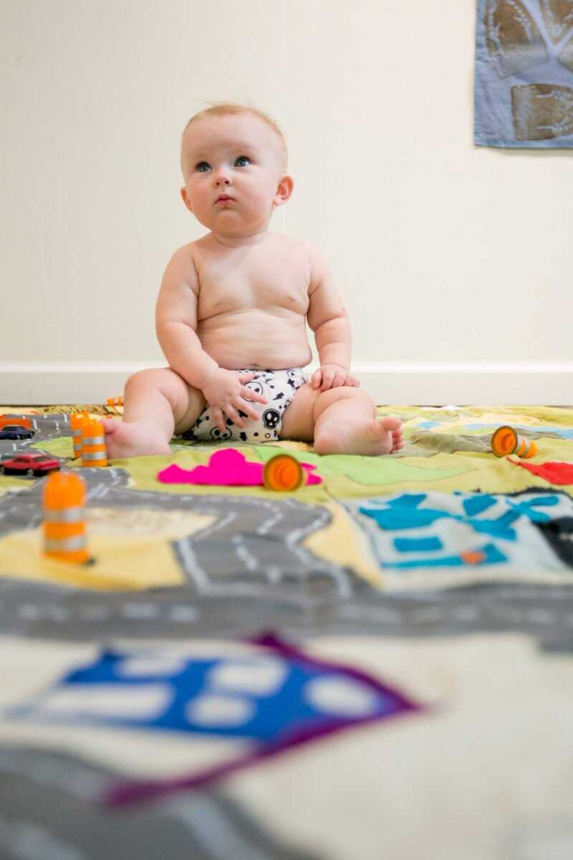 Levee, the son of Blake and Hannah Sanders plays on a quilt that is part of their exhibit at the Arts Council of Southeast Missouri Thursday, Oct. 8, 2015. (Glenn Landberg)