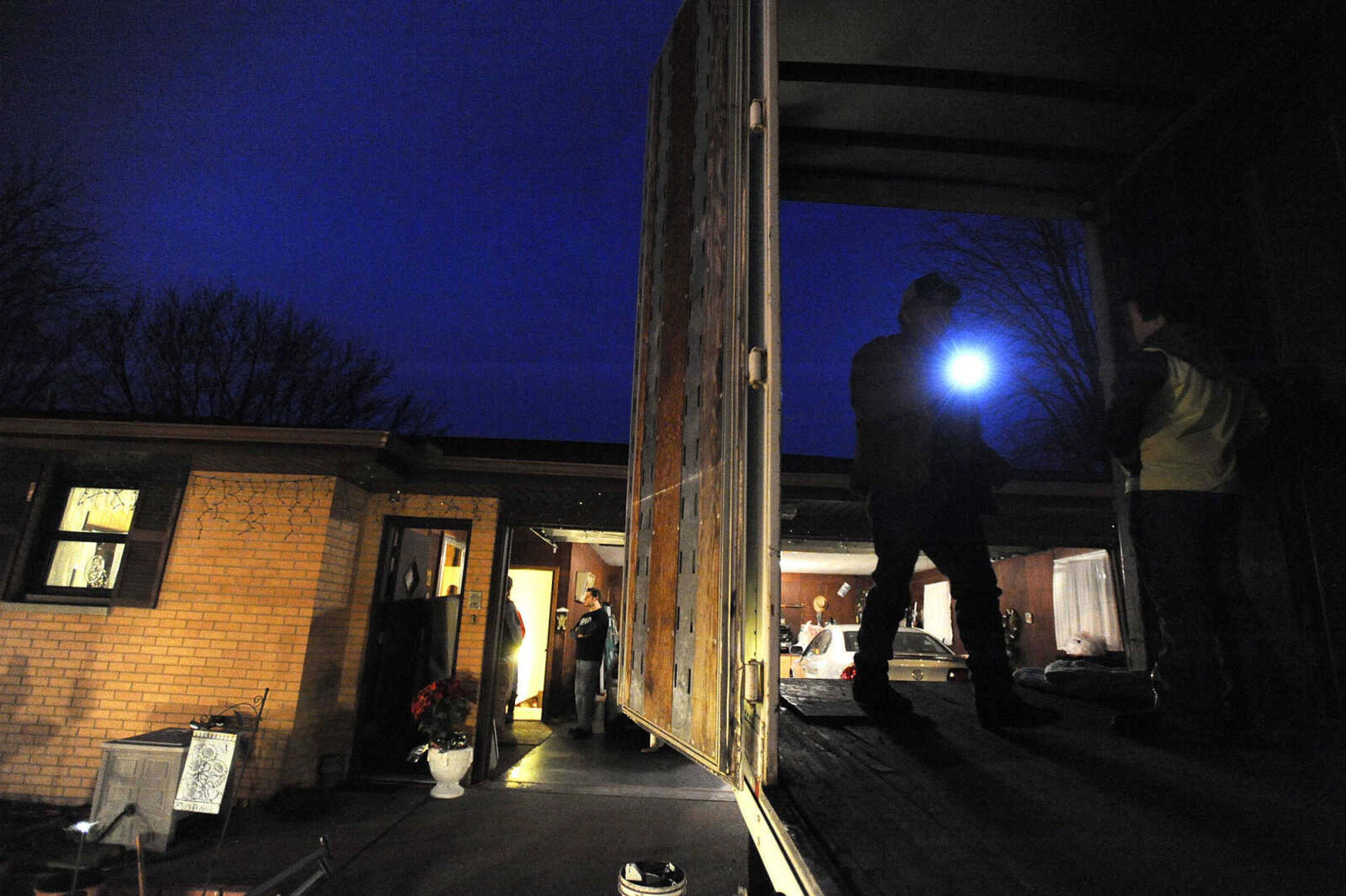 LAURA SIMON ~ lsimon@semissourian.com

Scott Miller shines a flashlight into the back of a tractor trailer while helping family evacuate their home in McLure, Illinois, Thursday, Dec. 31, 2015.