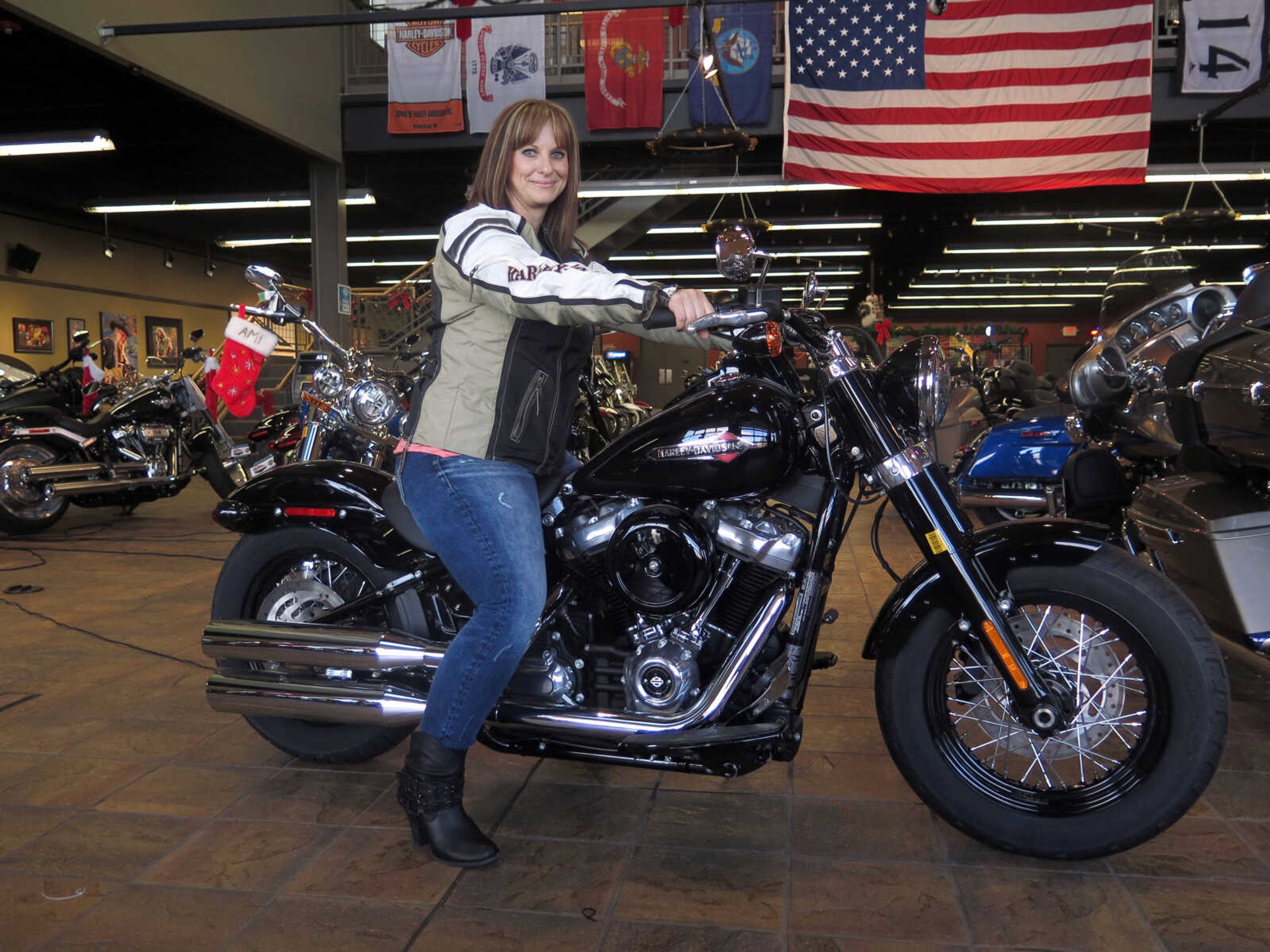 Terri Meehan poses on a 2018 Harley Softail Slim on Dec. 12 in Milwaukee's House of Harley. Meehan took a riding course at the dealership as part of Harley-Davidson's "Riding Academy," an initiative the company hopes will help bring new customers.