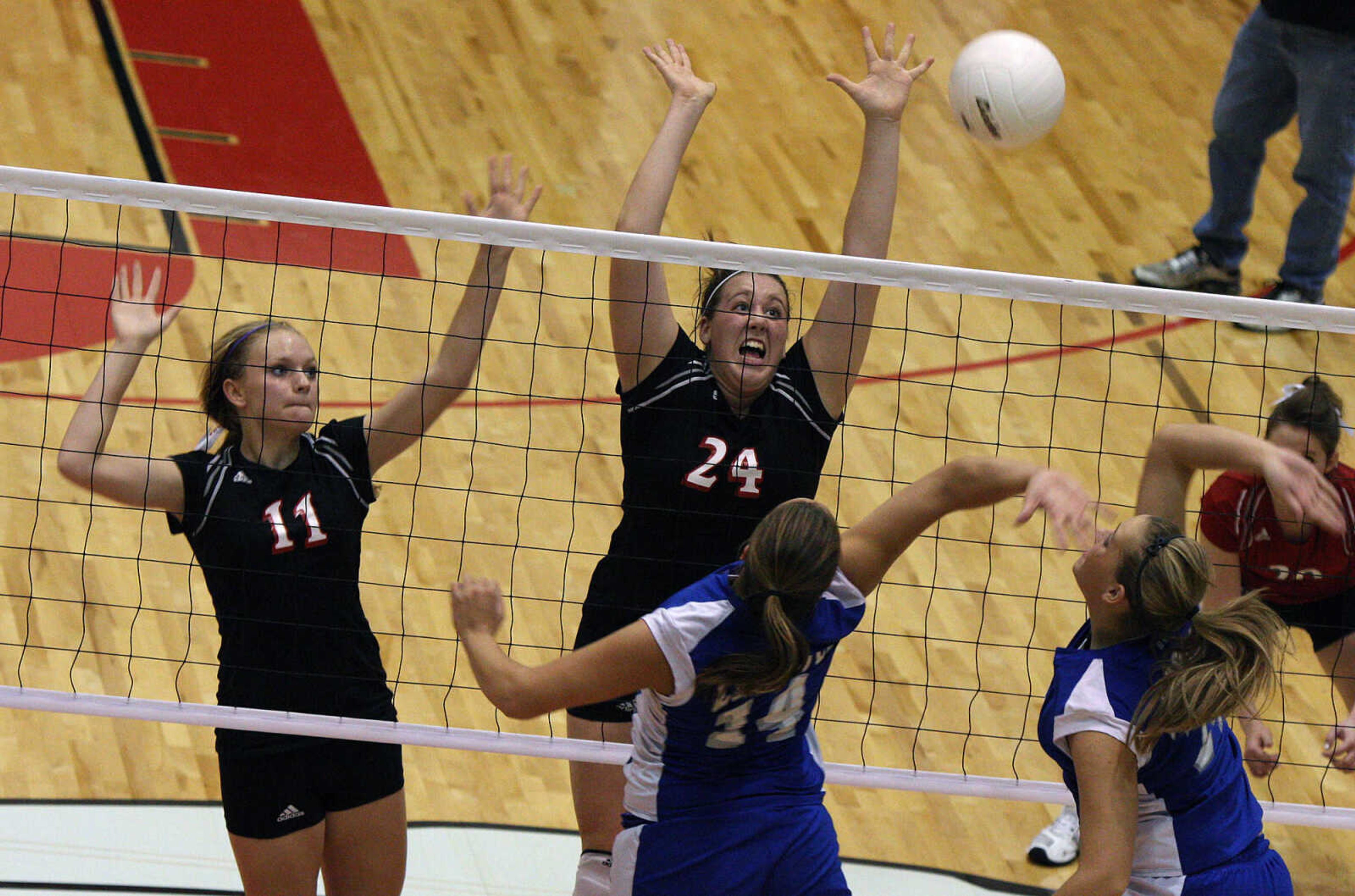 MaryAnn Bradshaw, left, and Jill Rushin, center, attack the net during their game against Leopold Thursday night.