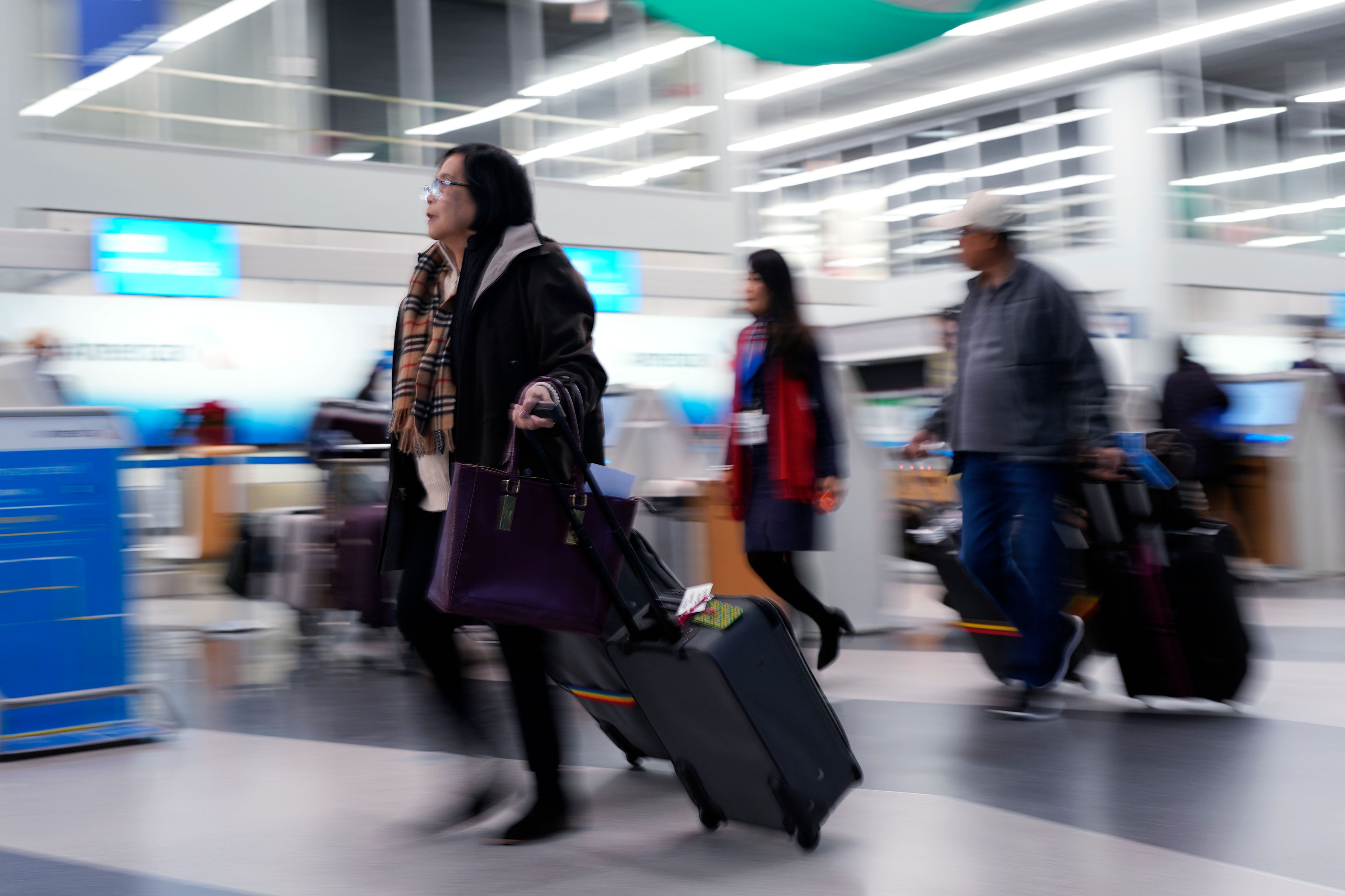 Travelers walk through Terminal 3 at O'Hare International Airport in Chicago, Tuesday, Nov. 26, 2024. (AP Photo/Nam Y. Huh)