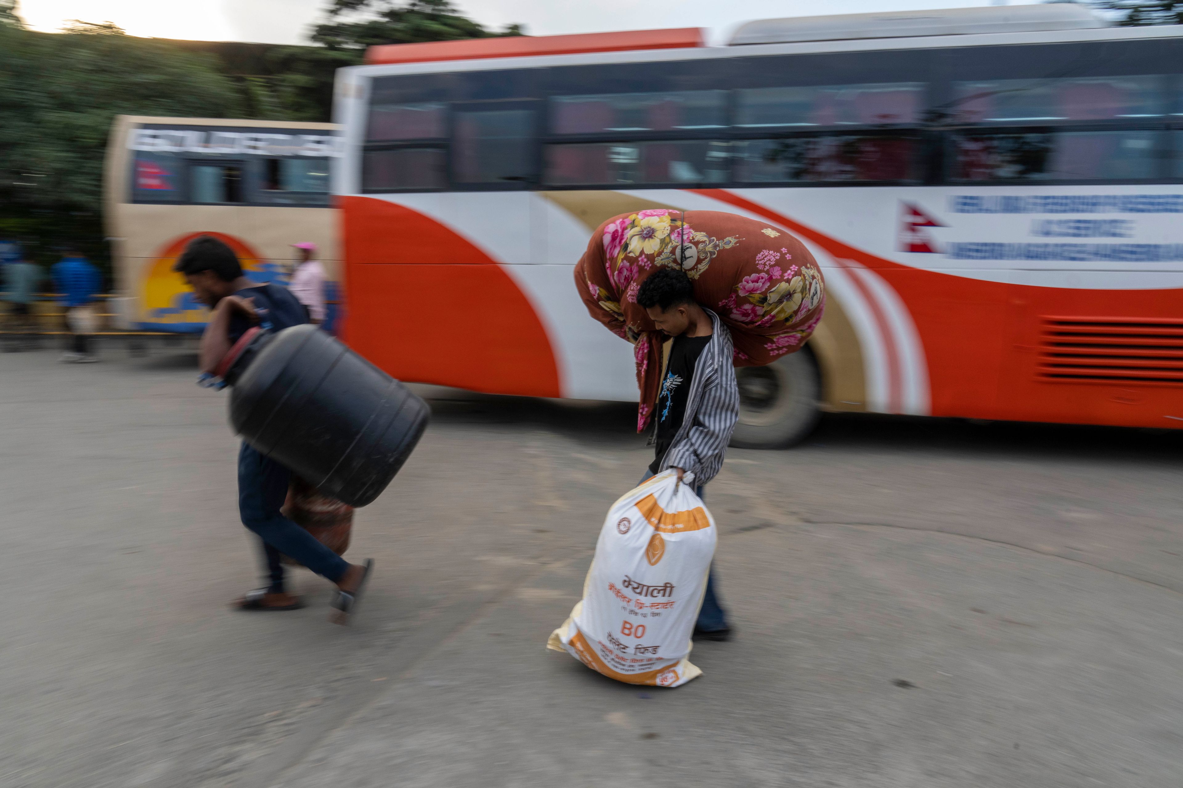 People arrive to catch buses to travel to their villages to celebrate the Dashain festival at a bus station in Kathmandu, Nepal, Thursday, Oct. 10, 2024. Dashain, the most important religious festival of Nepal's Hindus, commemorates the victory of the Gods over demons. (AP Photo/Niranjan Shrestha)