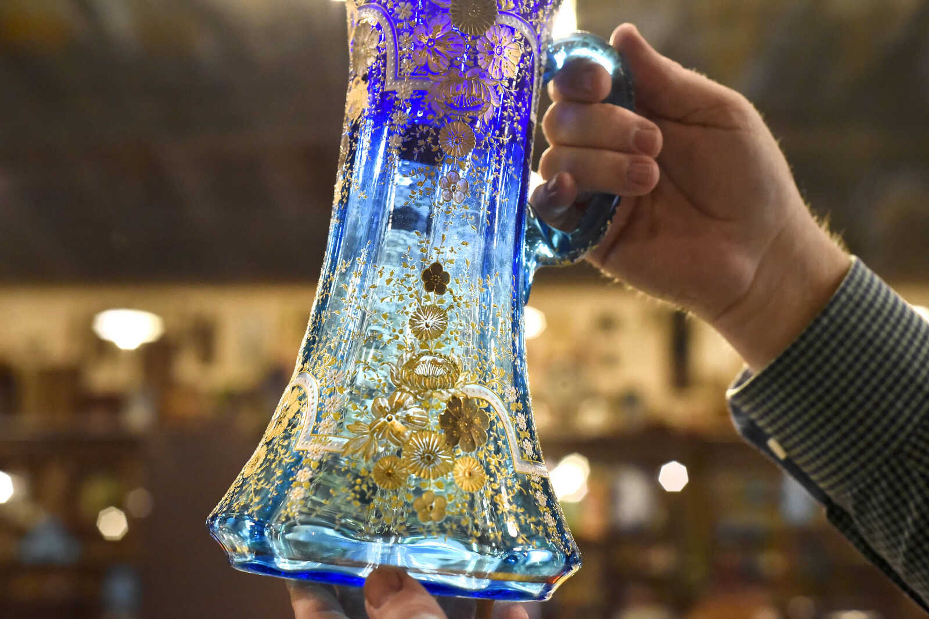 Harlan Smothers holds a colorful glass vessel inside Fat Chance General Store in Cape Girardeau County.