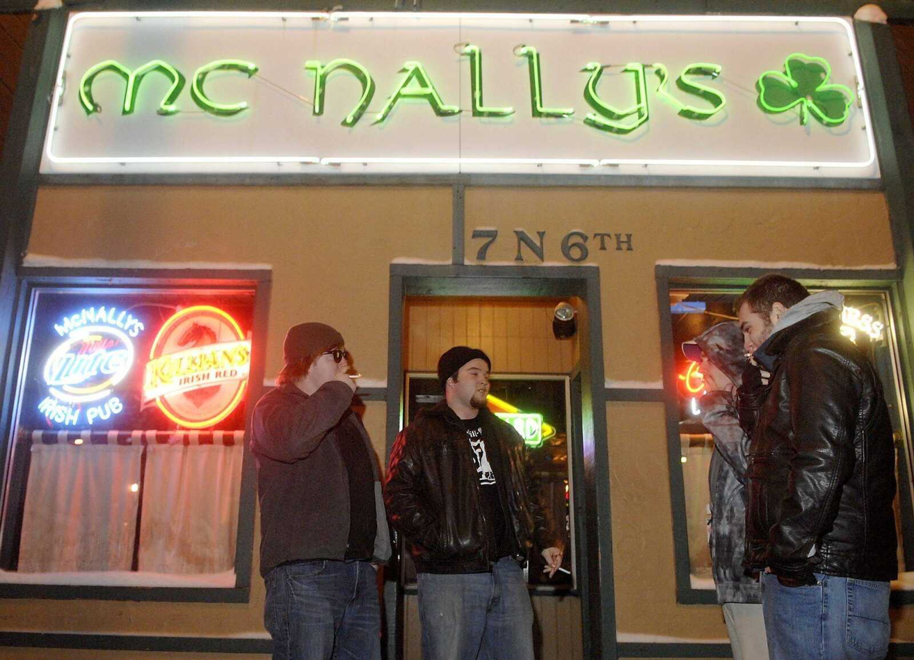 From left, Chris Masters, Levi Herborn, Brian Brock and Andrew Garcia smoke in front of McNally's Irish Pub in Columbia, Mo., on Tuesday. "It has its ups and downs &#8212; like tonight it's really cold and we can't be inside, but at the same time I can understand because I use to work in a restaurant and smoking in restaurants sucks," Masters said. "I understand the reason behind the smoking ban, but I thought that's what smoking sections were for," Garcia said. (DON SHRUBSHELL)