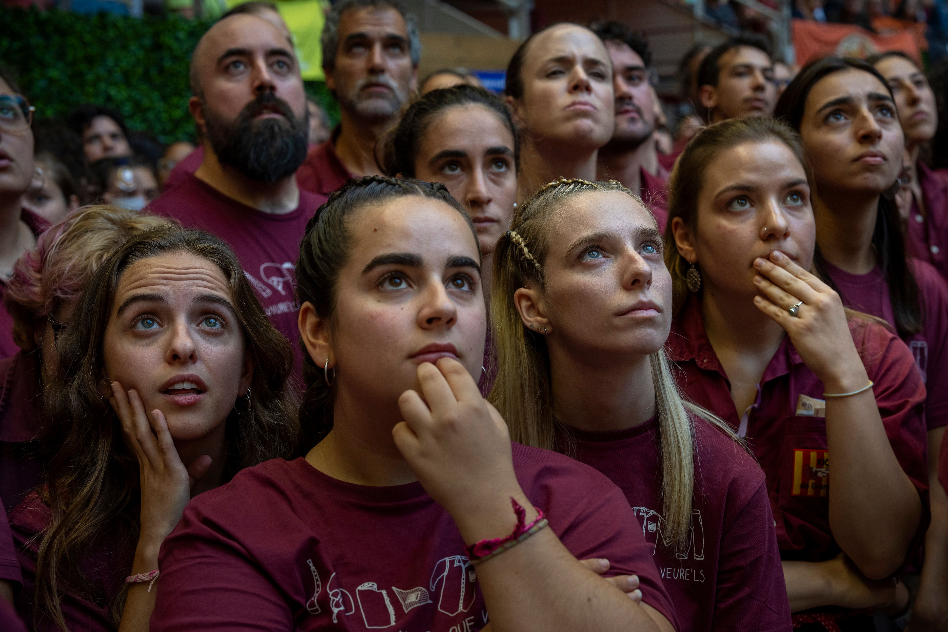 Assistants look as members of a "Castellers" form a human tower, during the 29th Human Tower Competition in Tarragona, Spain, Saturday, Oct. 5, 2024. (AP Photo/Emilio Morenatti)