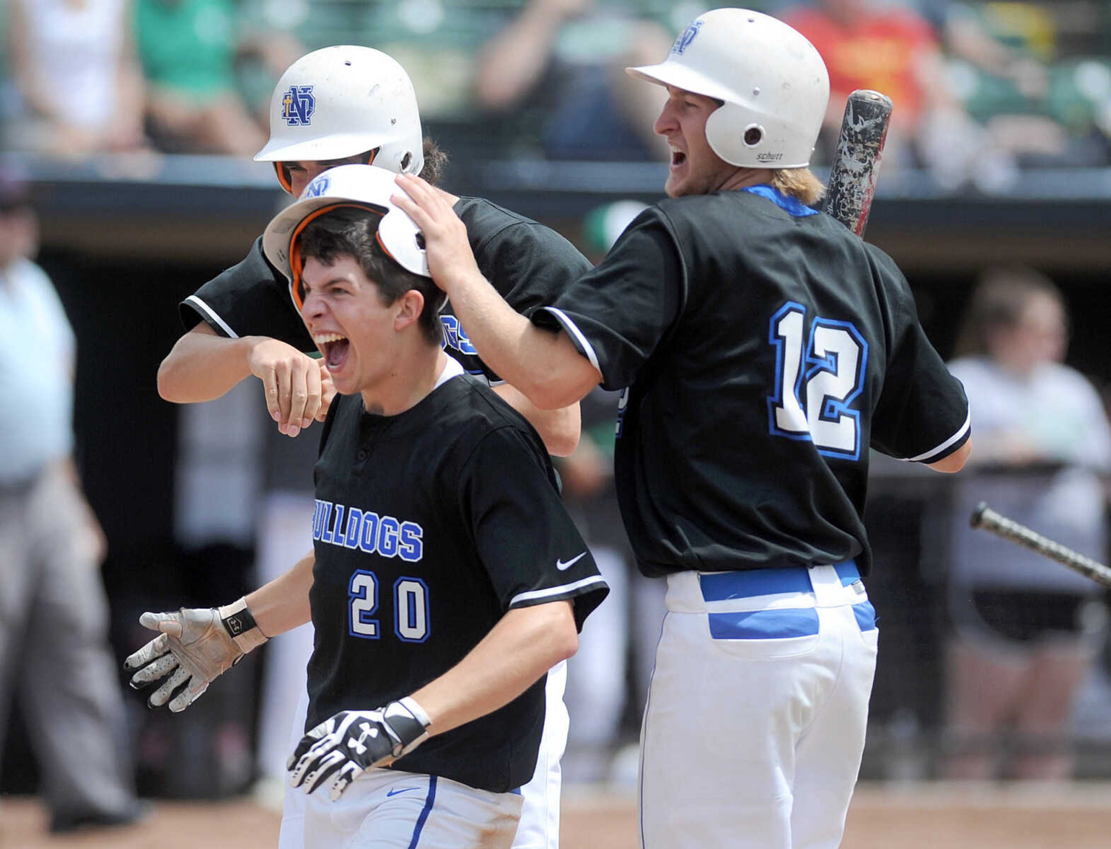 Notre Dame players congratulate Chase Urhahn on hitting a two-run RBI in the the top of the fourth inning of the Bulldogs Class 4 semifinal against Smithville, Friday, June 5, 2015, in O'Fallon, Missouri. Urhahn scored on an error. Notre Dame won 13-3 in six innings. (Laura Simon)