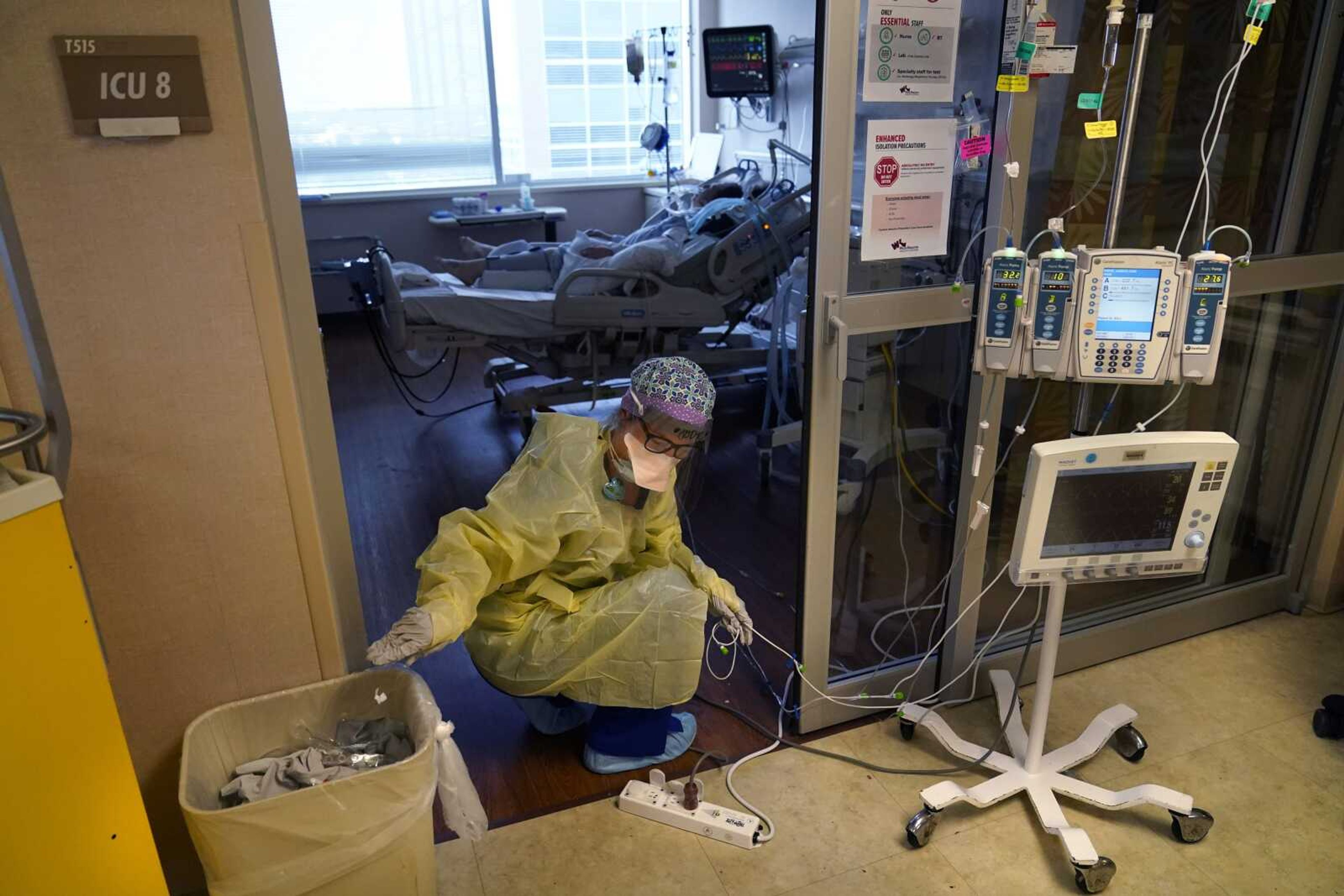 An ICU nurse moves electrical cords for medical machines outside the room of a patient suffering from COVID-19 in an intensive care unit at Willis-Knighton Medical Center on Aug. 17 in Shreveport, Louisiana.