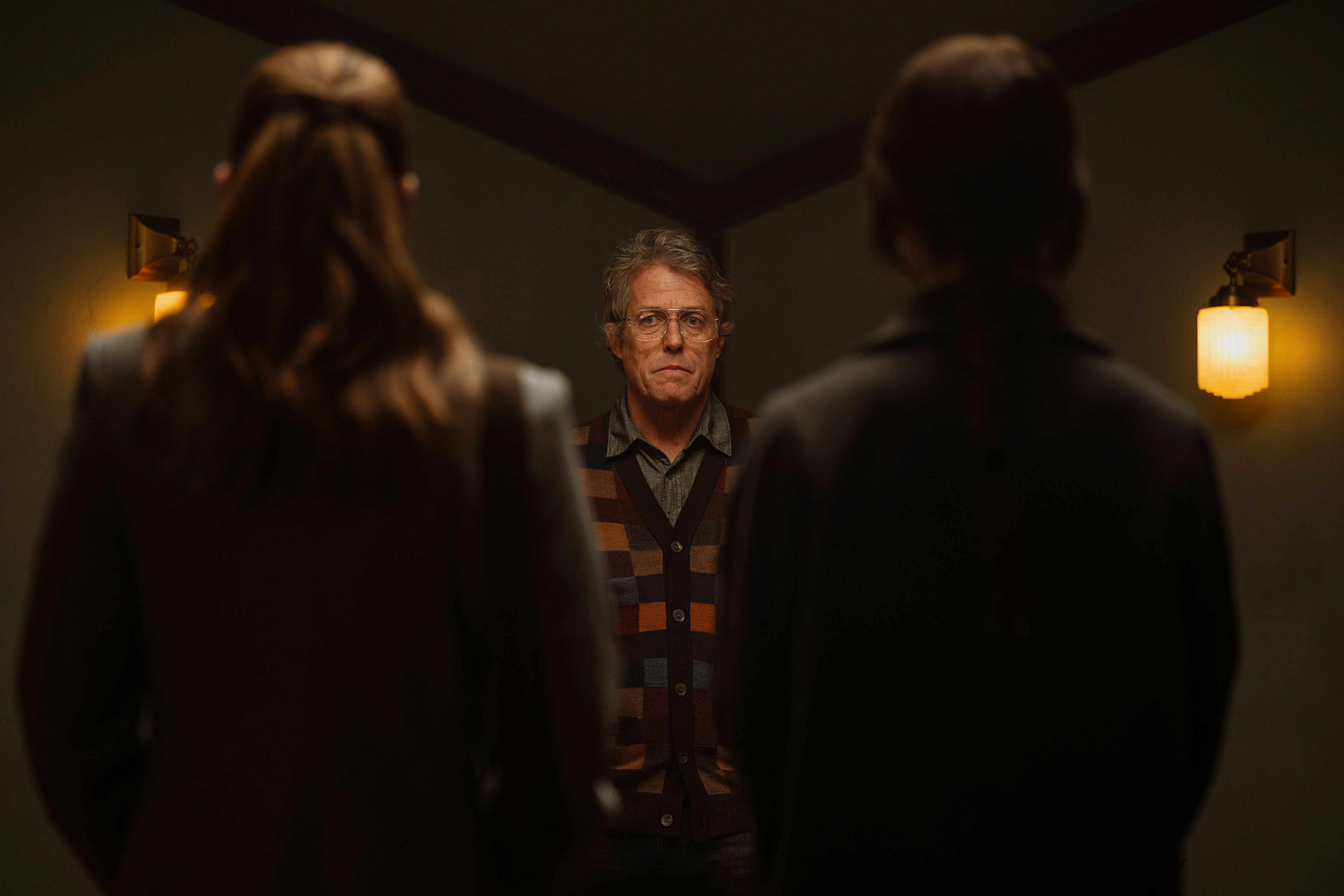 This image released by A24 shows, from left, Chloe East, Hugh Grant, and Sophie Thatcher in a scene from "Heretic." (Kimberley French/A24 via AP)