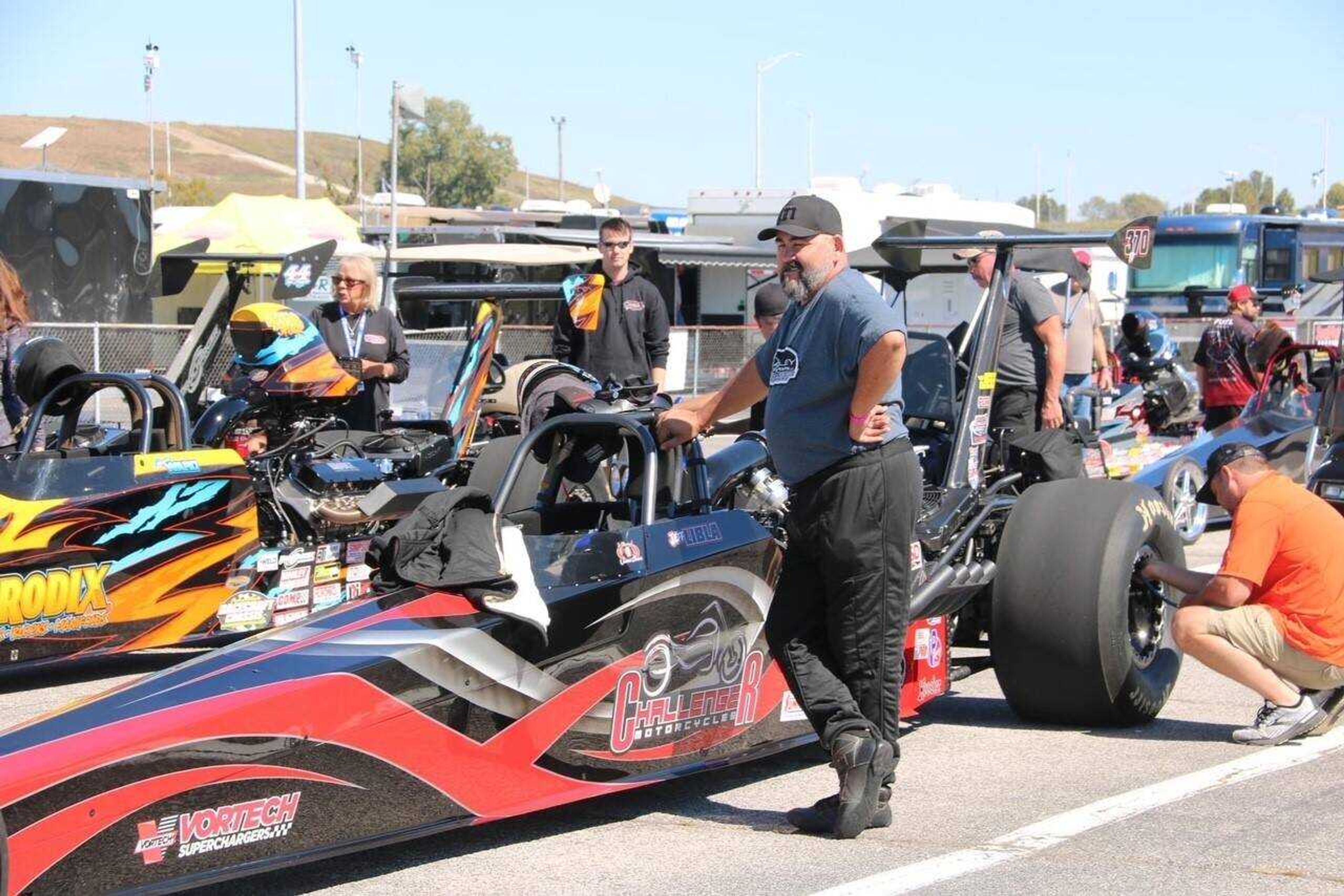 Jeff Libla stands next to his dragster as it's serviced before a race. He started drag racing again in 2016, after his two sons were grown. 