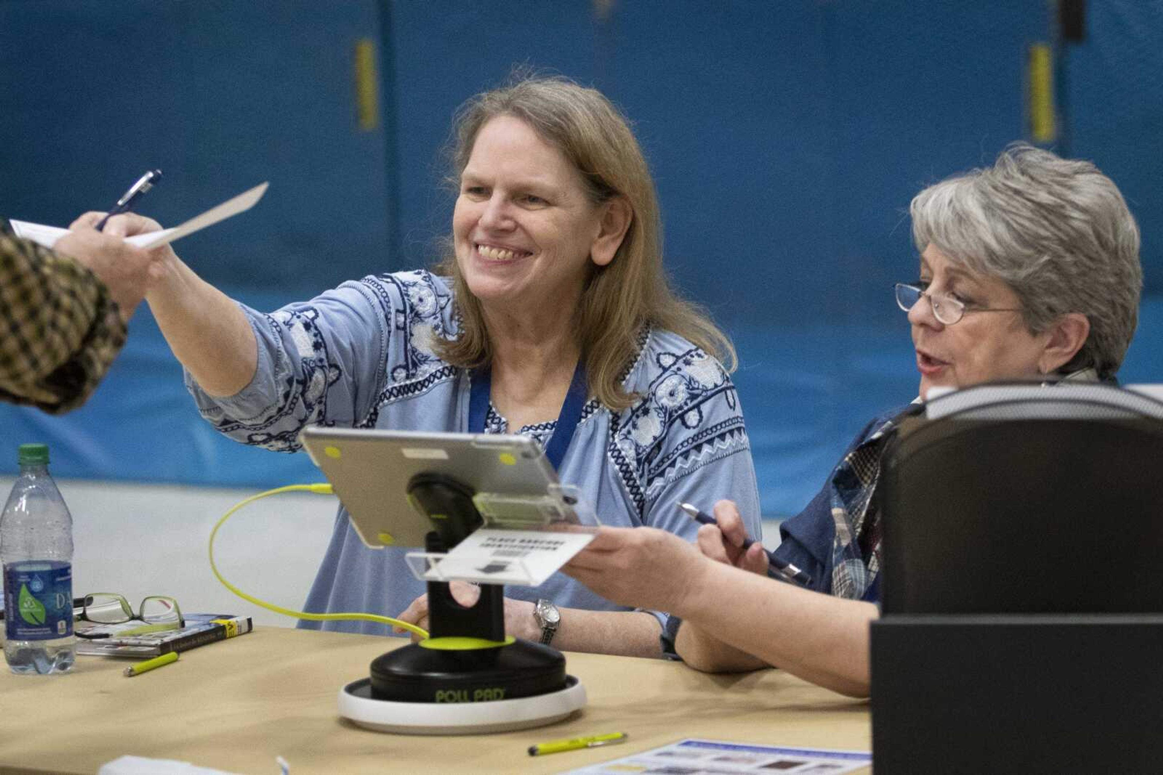 Election judges Linda Dedert, left, and Peggy Bentlage, both of Cape Girardeau, help a voter on election day Tuesday at Arena Building in Cape Girardeau.