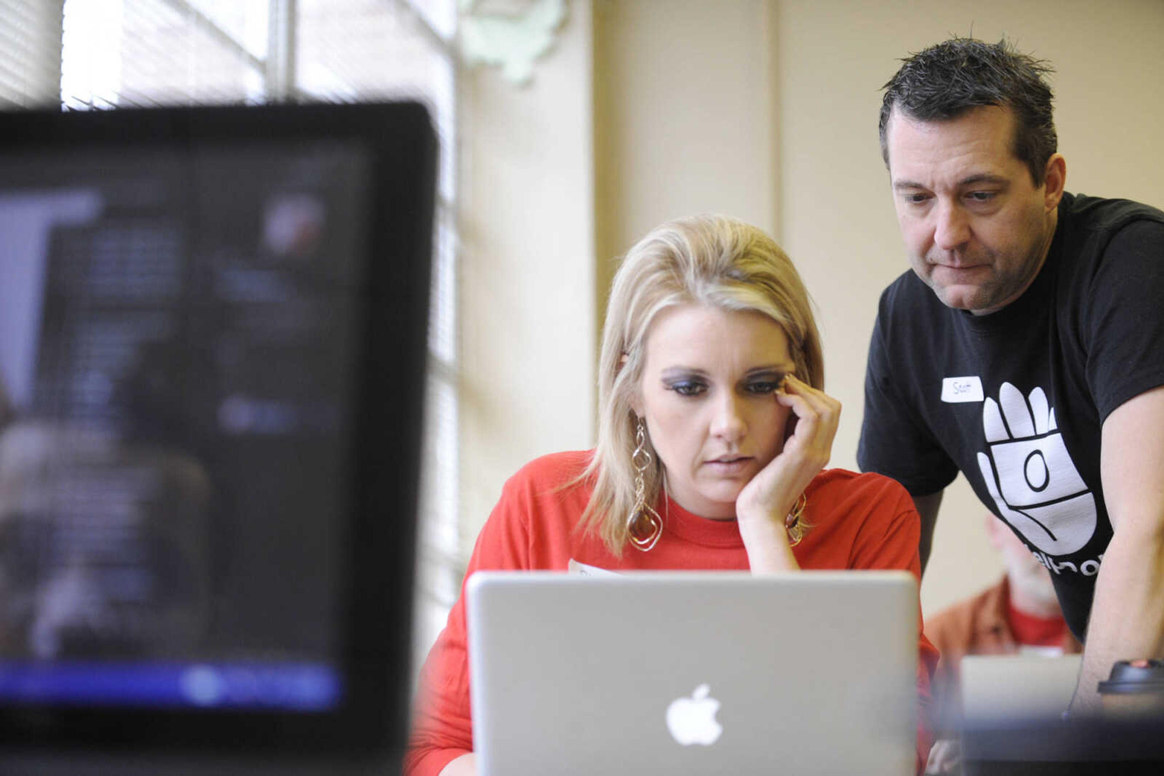 GLENN LANDBERG ~ glandberg@semissourian.com

Scott Slinkard helps Sheena Faught with a photo editing question during the fifth annual Help-Portrait event Saturday, Dec. 6, 2014 at the House of Hope in Cape Girardeau.