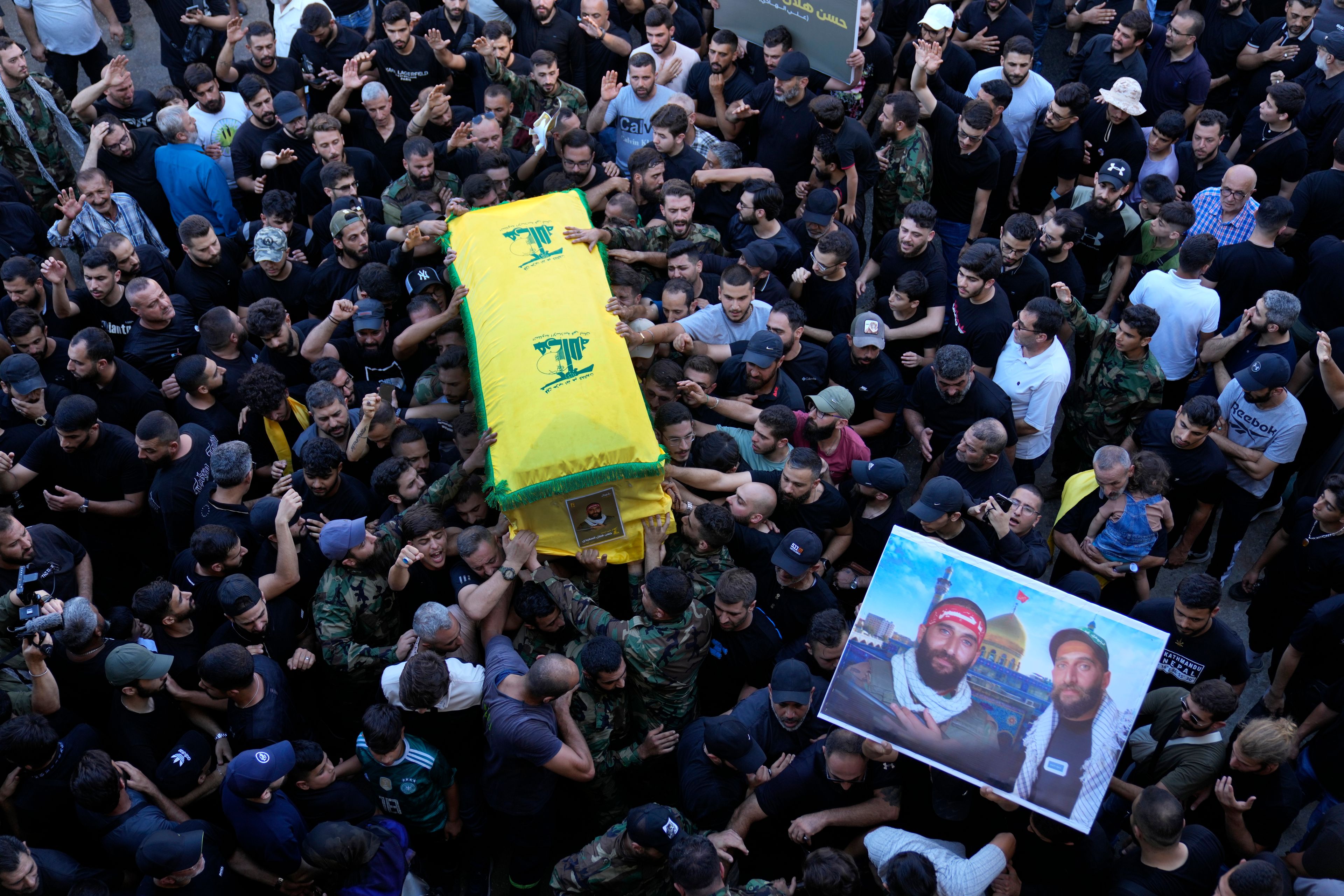 Mourners carry the coffin of a Hezbollah fighter who was killed with three other fighters on Saturday by an Israeli airstrike in south Lebanon, during their funeral procession in the southern suburb of Beirut, Lebanon, Sunday, July 28, 2024. (AP Photo/Hussein Malla)