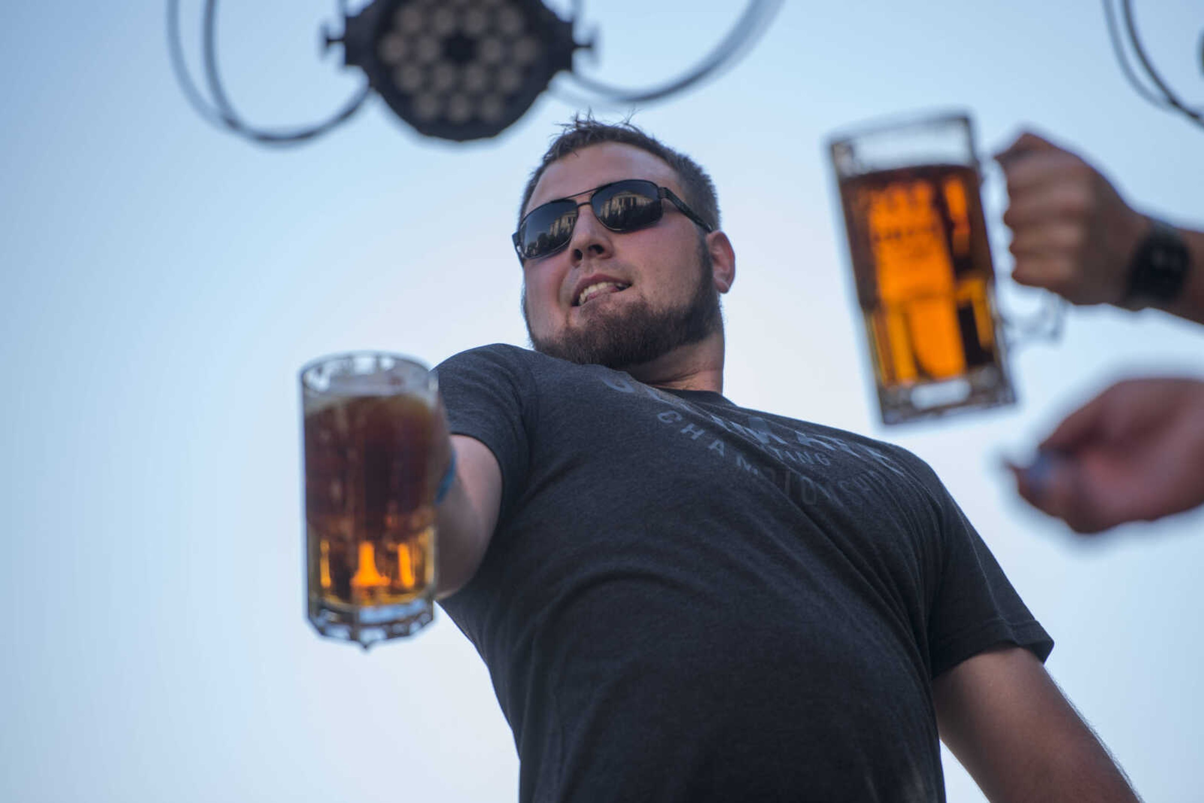 Contestants strain to keep their steins aloft in a competition during Uptown Jackson Oktoberfest Saturday, Oct. 6, 2018.