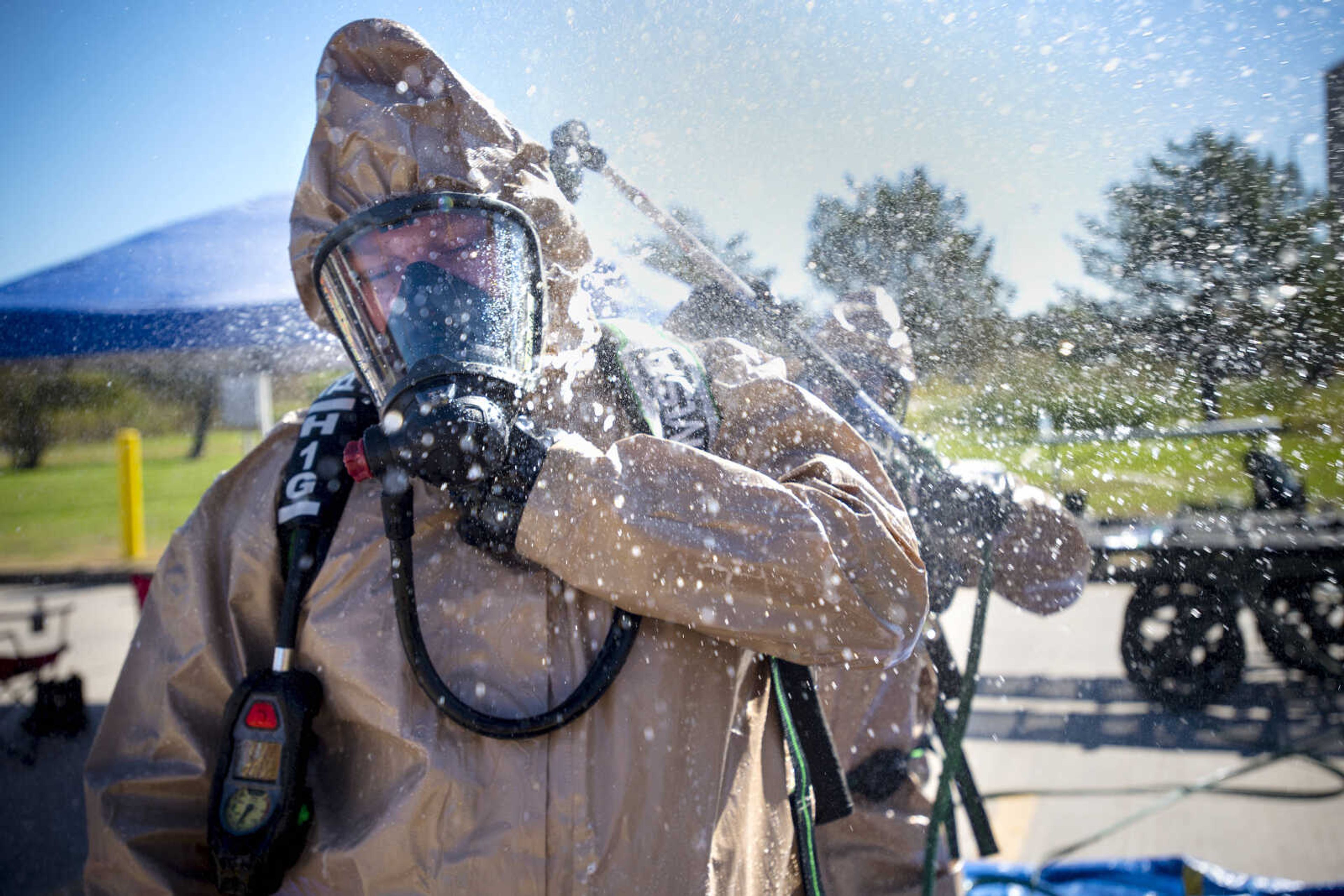 SEMO Homeland Security Response Team member Devin Wierschem, back right, sprays down Zak Haskin in a decontamination station during hazmat training on Wednesday, Oct. 17, 2018, at the Cape Girardeau Buzzi Unicem cement plant.