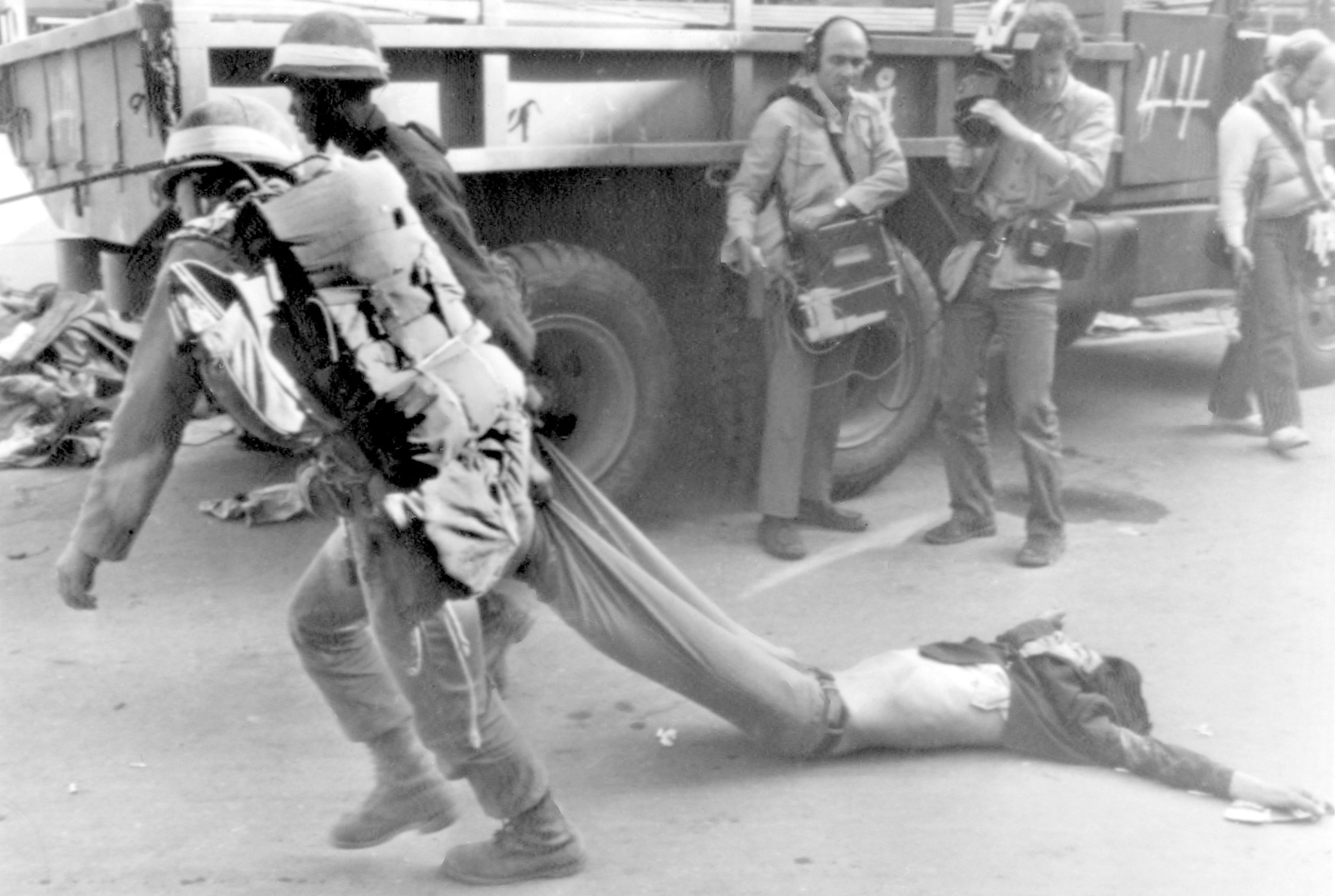 FILE- Soldiers carry away the body of a rebel killed in a firefight Tuesday May 27, 1980, when South Korean troops recaptured this riot-battered city of Gwangju (Kwangju). (AP Photo/File)