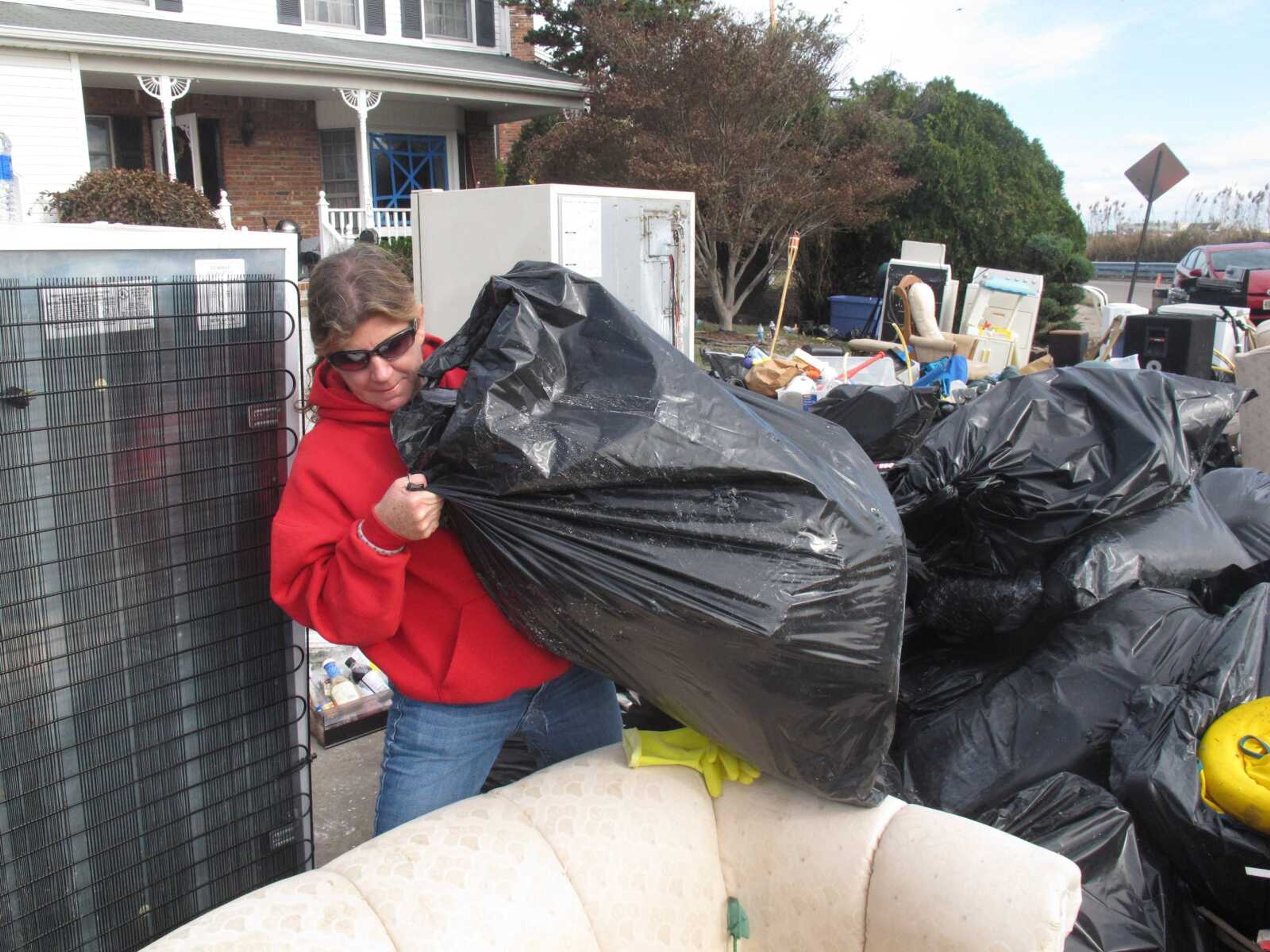 Laura DiPasquale sorts through bags of possessions that volunteers removed from her home in Point Pleasant Beach N.J. on Monday, Nov. 5, 2012. DiPasquale is frantically looking through them to see if well-meaning volunteers discarded anything she intended to keep before a second storm hits the shore on Wednesday, raising the possibility of renewed flooding and damage. (AP Photo/Wayne Parry)