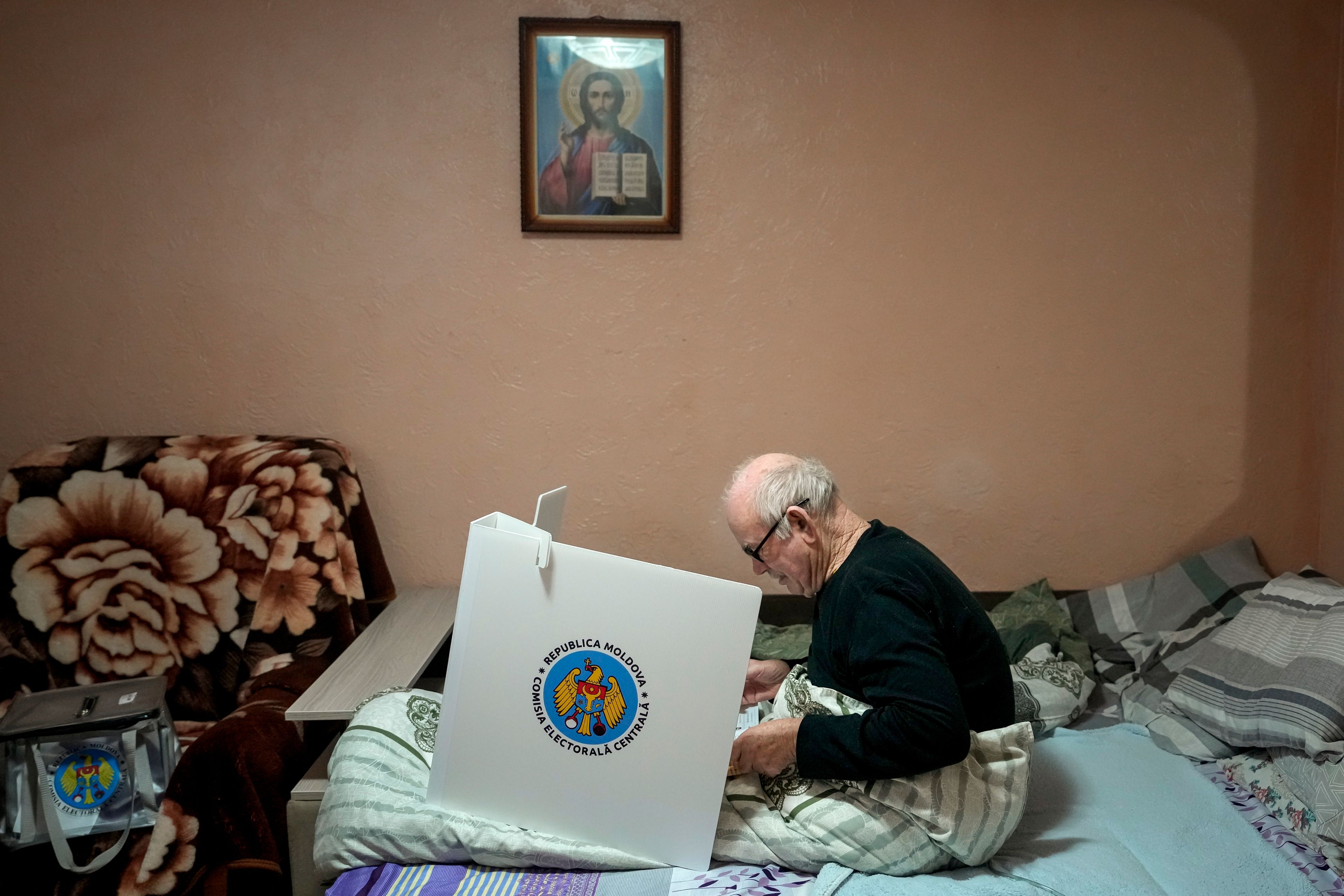 A man casts his vote in a mobile ballot box in the village of Hrusevo, Moldova, Sunday, Oct. 20, 2024, during a presidential election and a referendum on whether to enshrine in the Constitution the country's path to European Union membership. (AP Photo/Vadim Ghirda)