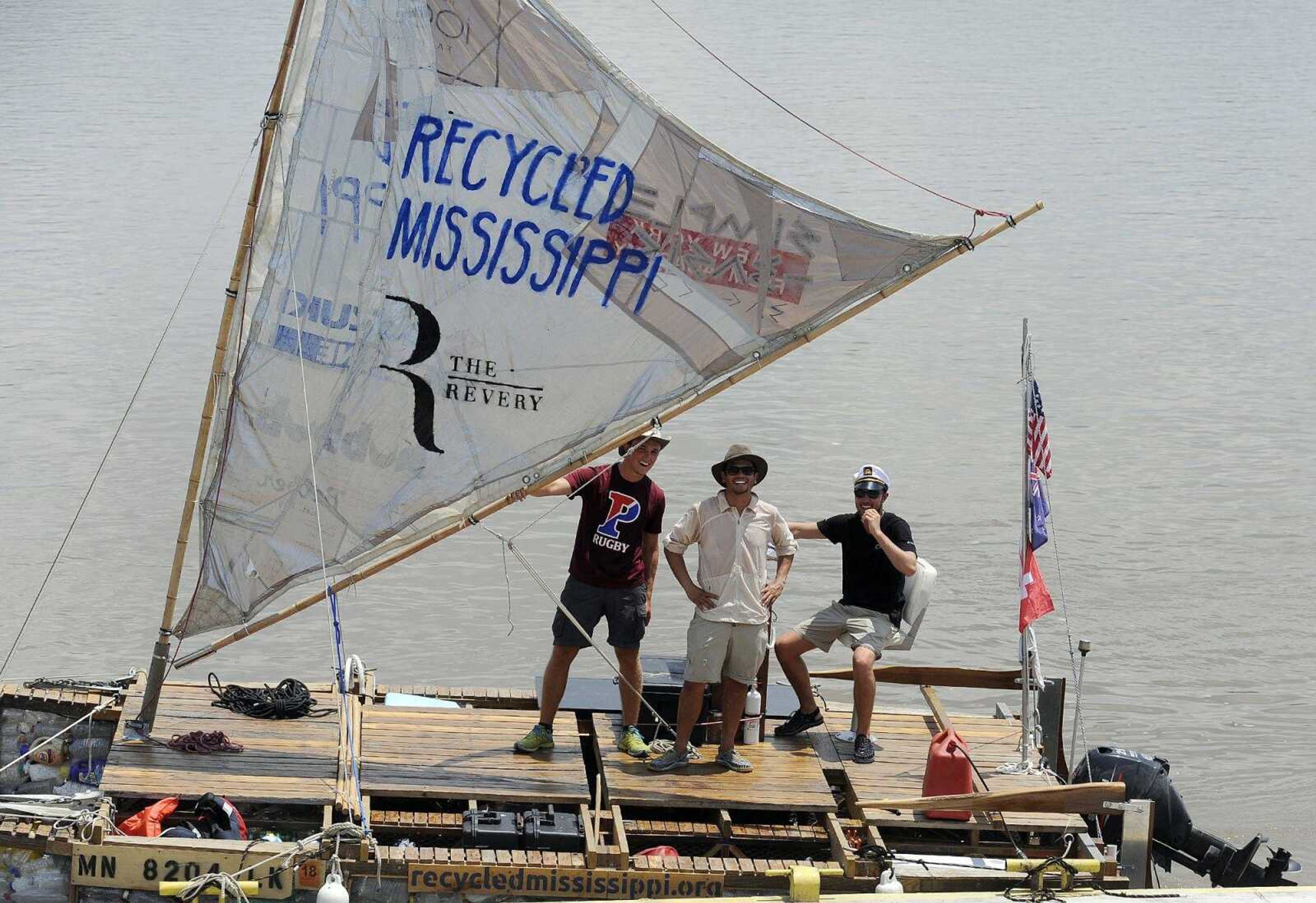 Sebastian Englehart, left, Dan Cullum, center, and Gary Bencheghib pose for a photo Tuesday on the boat they and three others are traveling on down the Mississippi River. The boat they are traveling on is made of recycled materials.