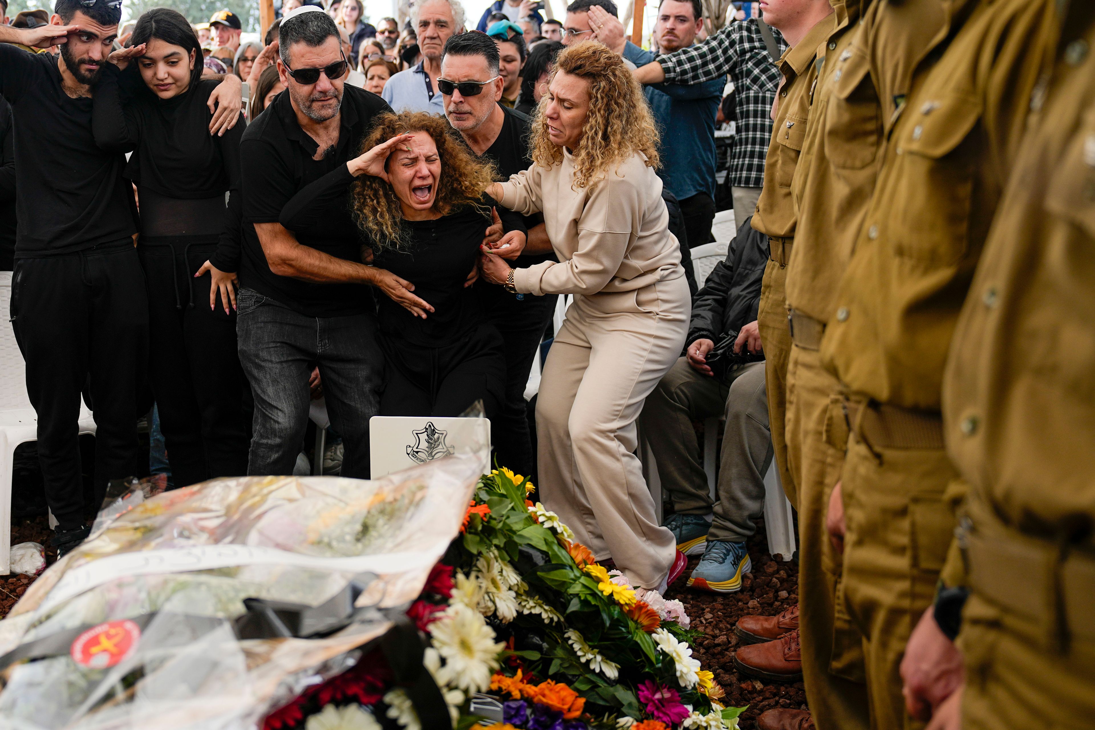 Sivan, mother of Israeli soldier, Sergeant Dolev Malca, was killed during Israel's ground operation in the Gaza Strip, screams as she salutes her son during his funeral in Shlomi, northern Israel, on the border with Lebanon, Sunday, March 3, 2024. (AP Photo/Ariel Schalit)