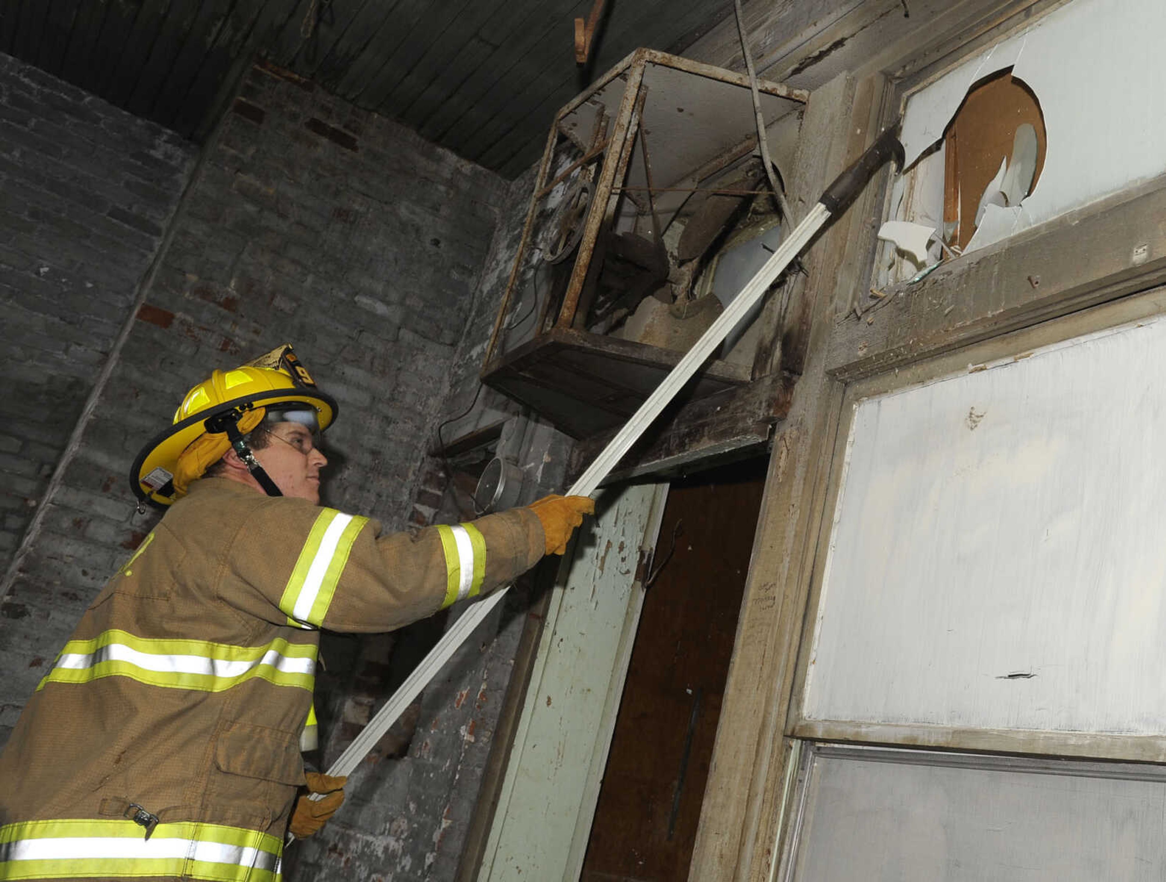 Firefighter Bryan Stroer breaks an interior window during the training session.