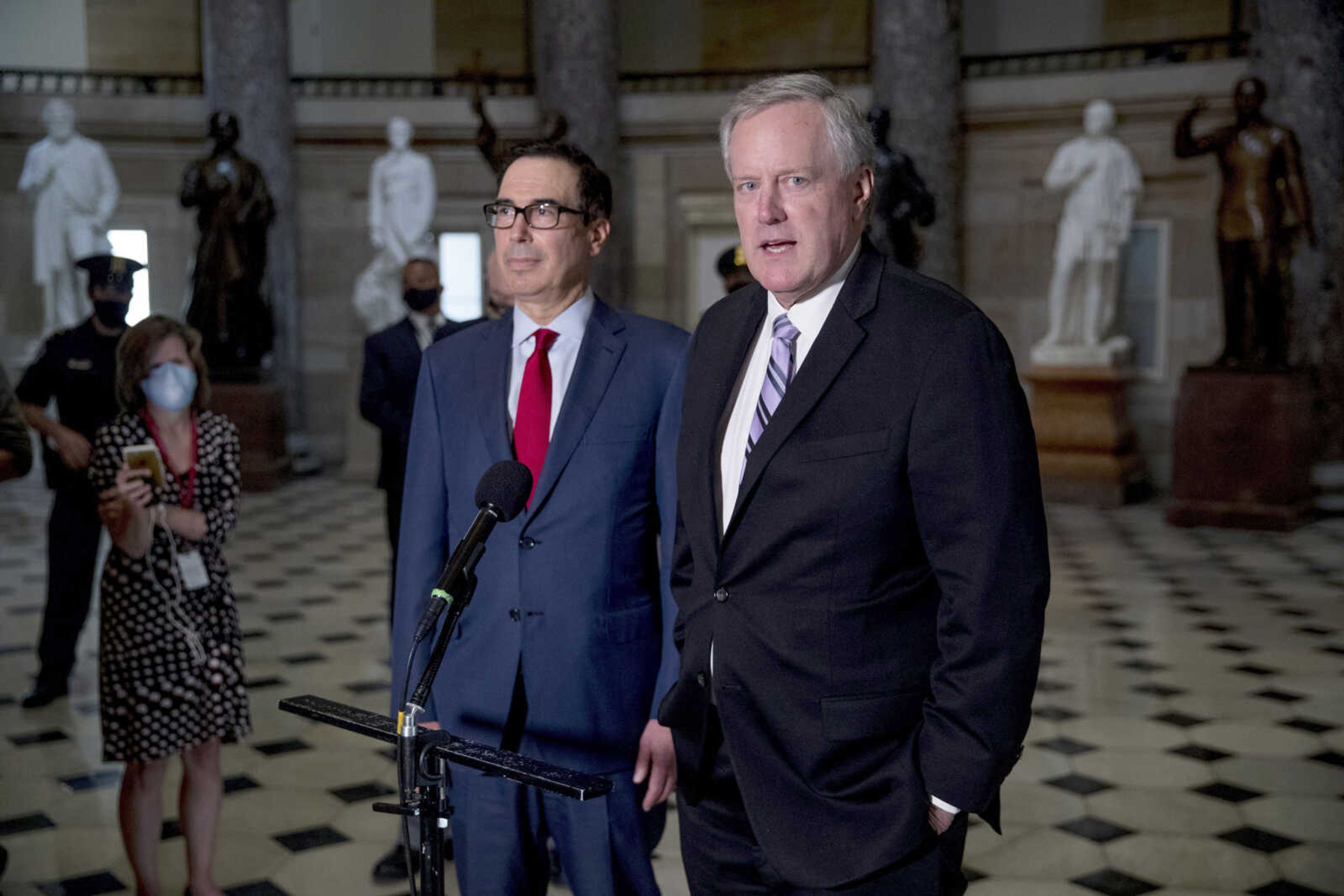 White House Chief of Staff Mark Meadows, right, accompanied by Treasury Secretary Steven Mnuchin, left, speaks to reporters after meeting with House Speaker Nancy Pelosi of California and Senate Minority Leader Sen. Chuck Schumer of New York as they continue to negotiate a coronavirus relief package on Capitol Hill on Aug. 7 in Washington.