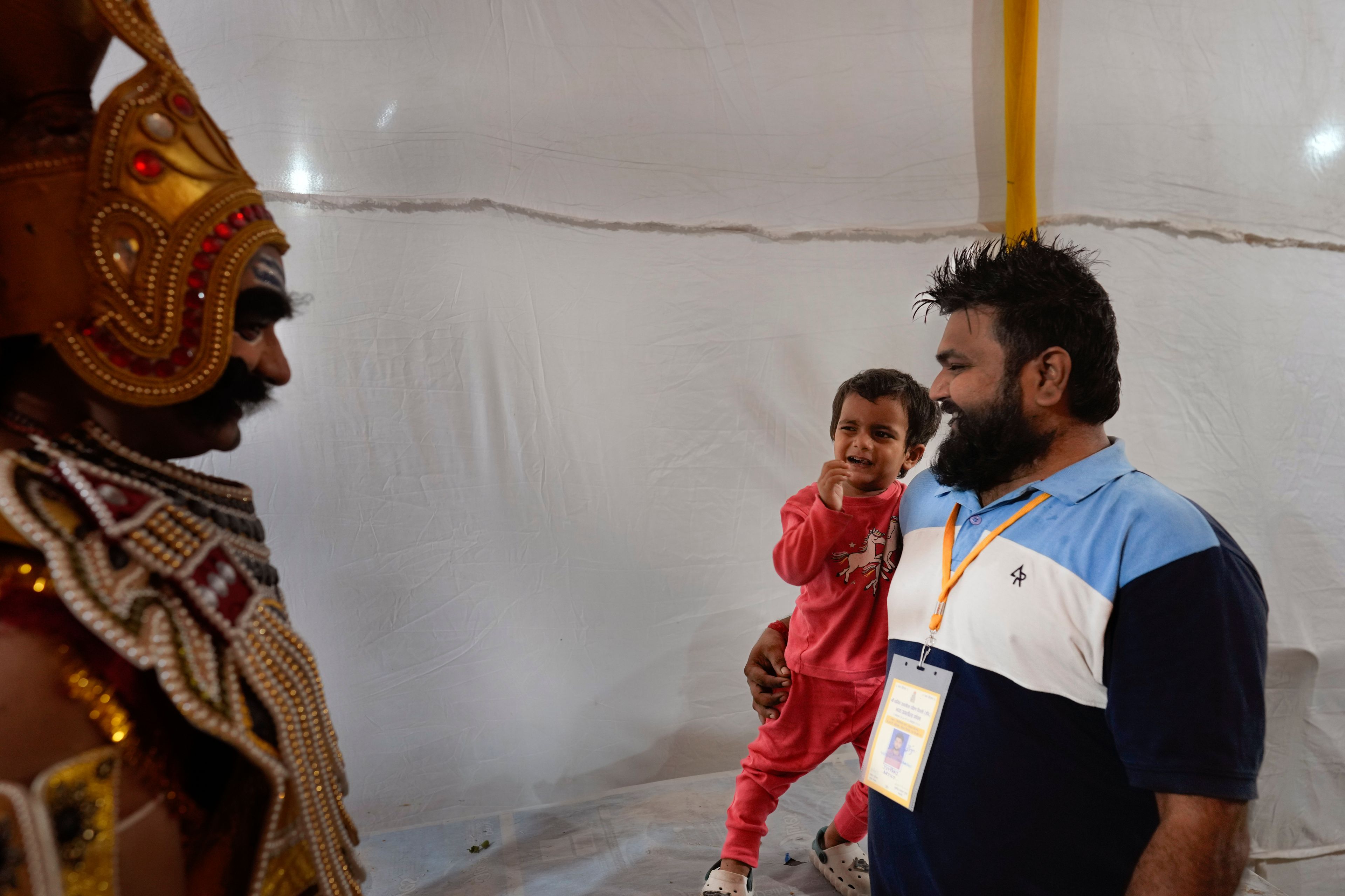 A child reacts as Vikas Sirswal, 32, playing the character of the demon king Ravana, walks past after performing in Ramleela, a dramatic folk re-enactment of the life of Hindu god Rama according to the ancient Hindu epic Ramayana, in New Delhi, India, Wednesday, Oct. 9, 2024. (AP Photo/Manish Swarup)