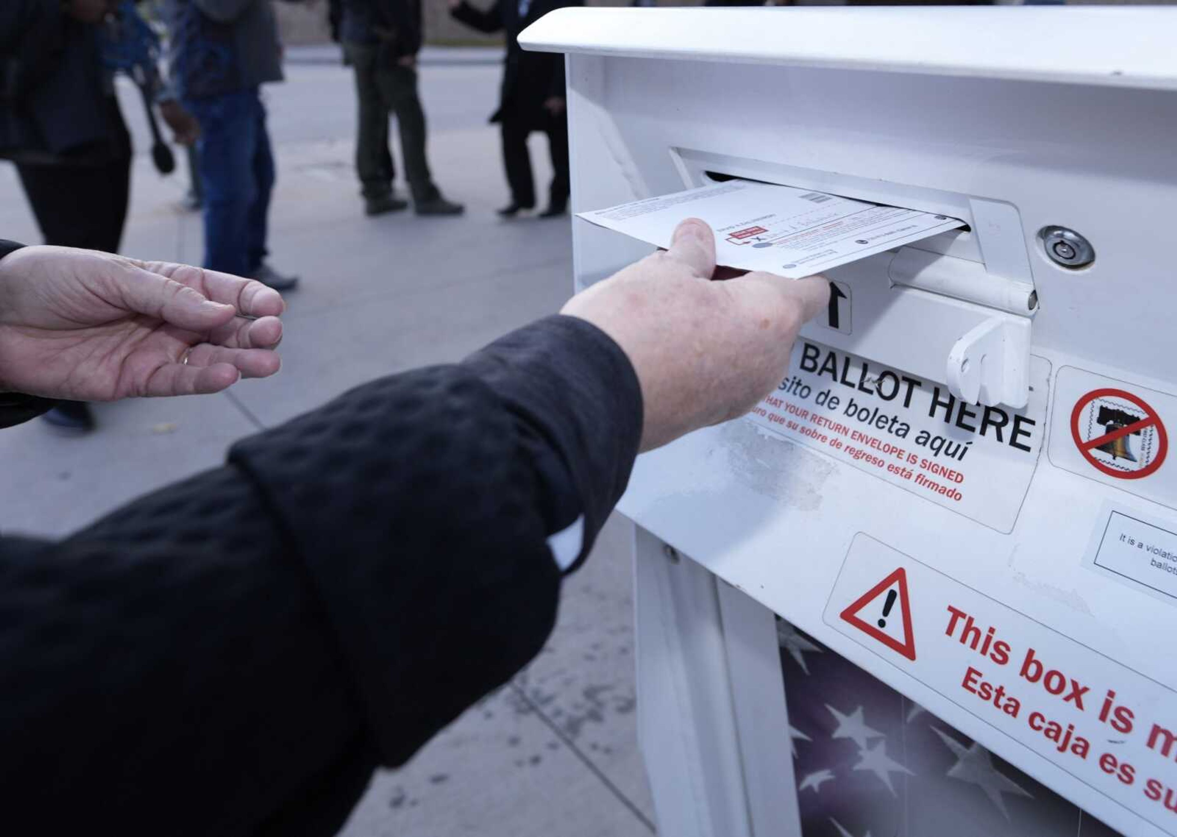 A voter places a ballot in a drop box outside the Denver Elections Division headquarters Nov. 8 in downtown Denver.