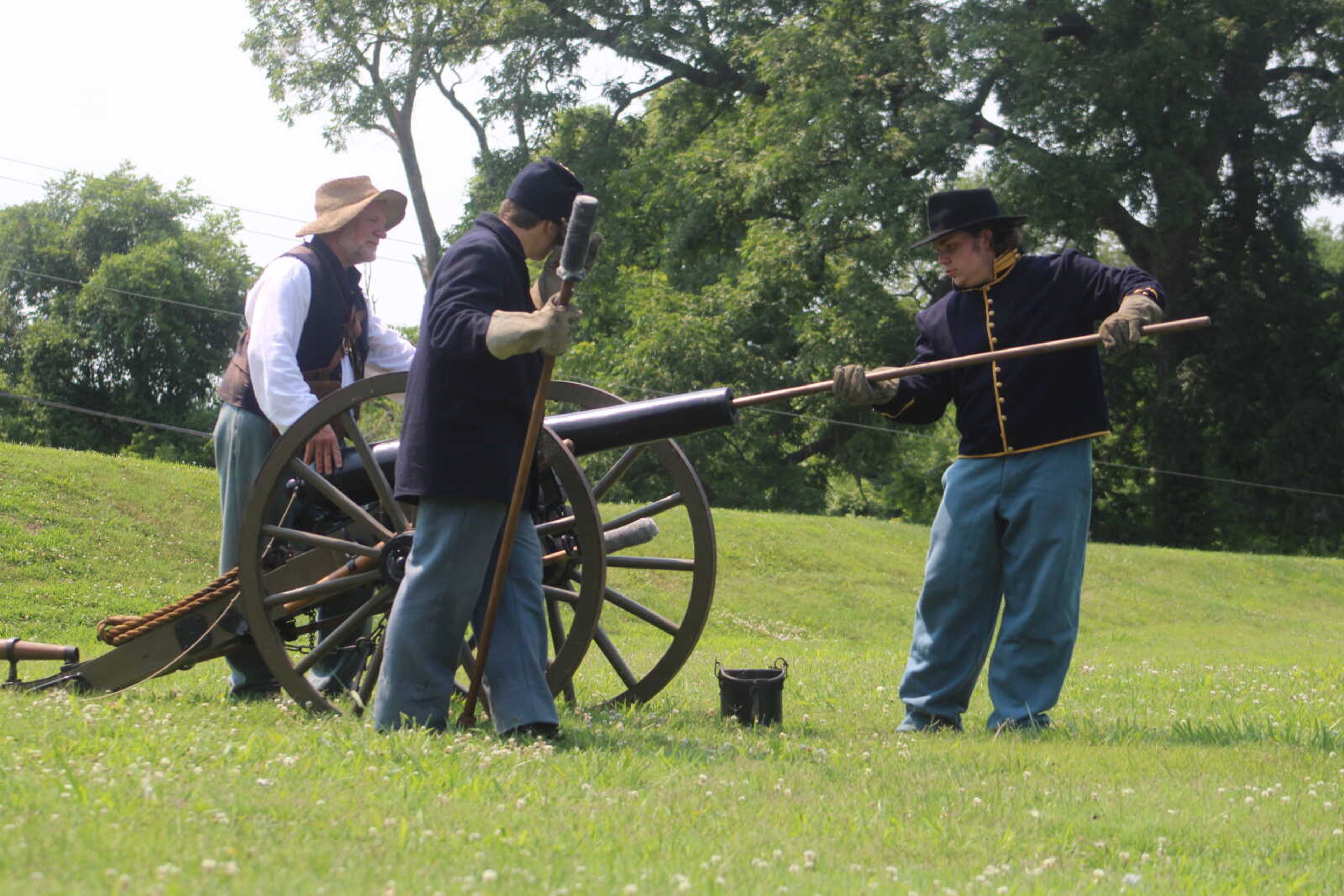 Dalton Blankenship, 15, right, prepares the replica cannon for a demonstration at Fort D Historic Site in Cape Girardeau on Sunday, July 4, 2021. Chris Wessel supervises from behind the replica cannon while Andrew Porter, 15, waits for his part in the demonstration.