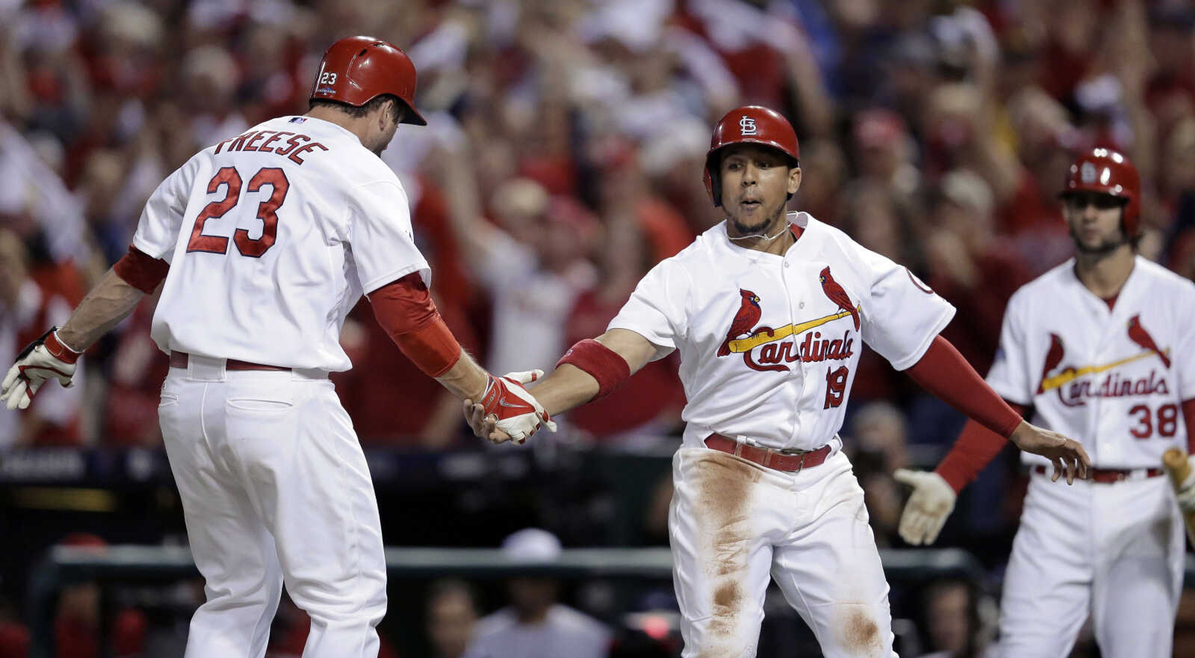 St. Louis Cardinals' David Freese (23) is greeted at home plate by Jon Jay (19) after Freese drove in Jay with a two-run home run against the Pittsburgh Pirates in the second inning of Game 5 of a National League baseball division series on Wednesday, Oct. 9, 2013, in St. Louis. At right is Pete Kozma. (AP Photo/Charlie Riedel)