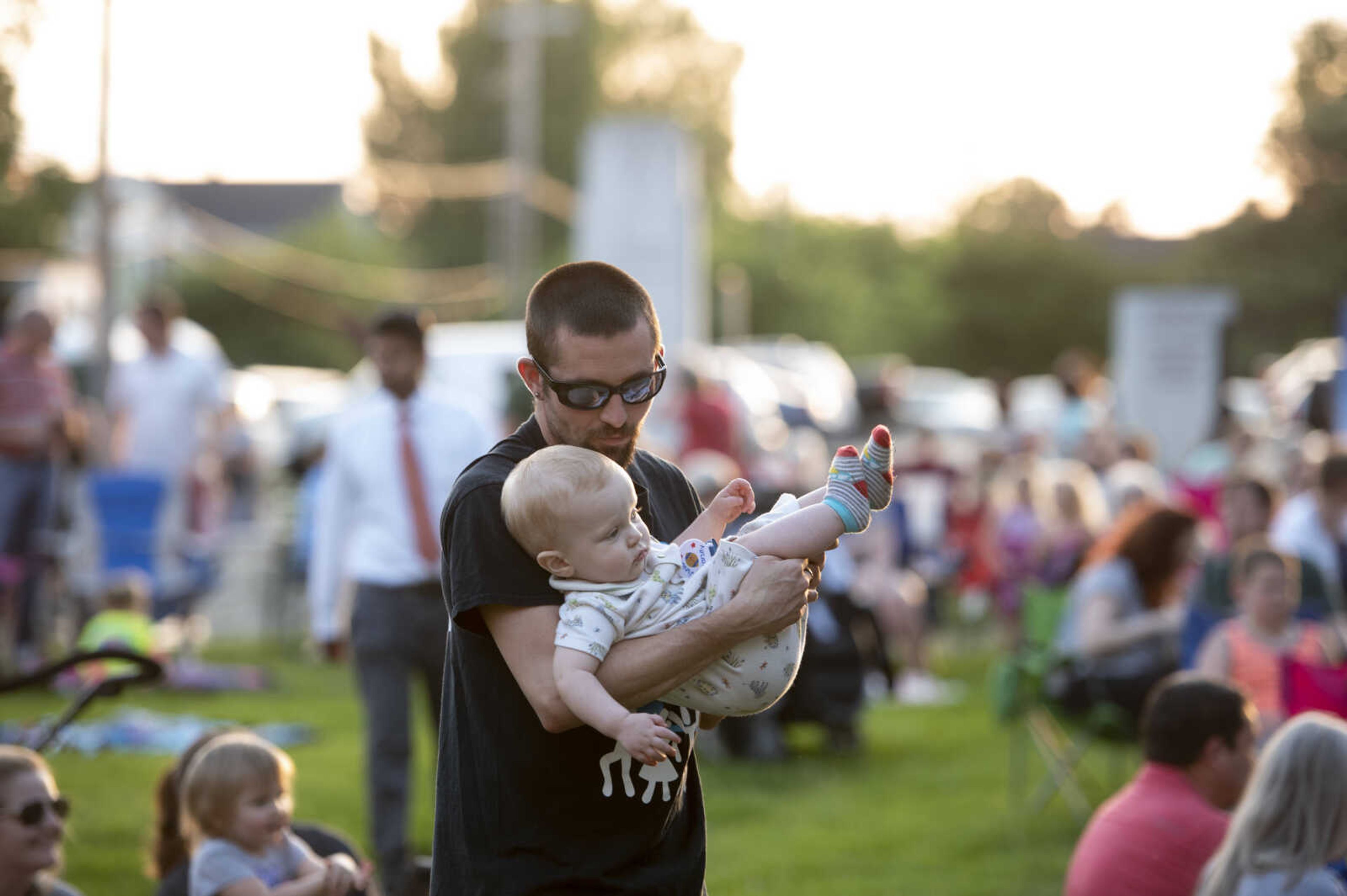 Isaiah Cope, originally from Portageville, Mo., and now Cape Girardeau, listens to the music of Paul Childers while holding his son Rylan Cope, 1, during the season's first Tunes at Twilight on Friday, May 17, 2019, at Ivers Square near Common Pleas Courthouse in Cape Girardeau.